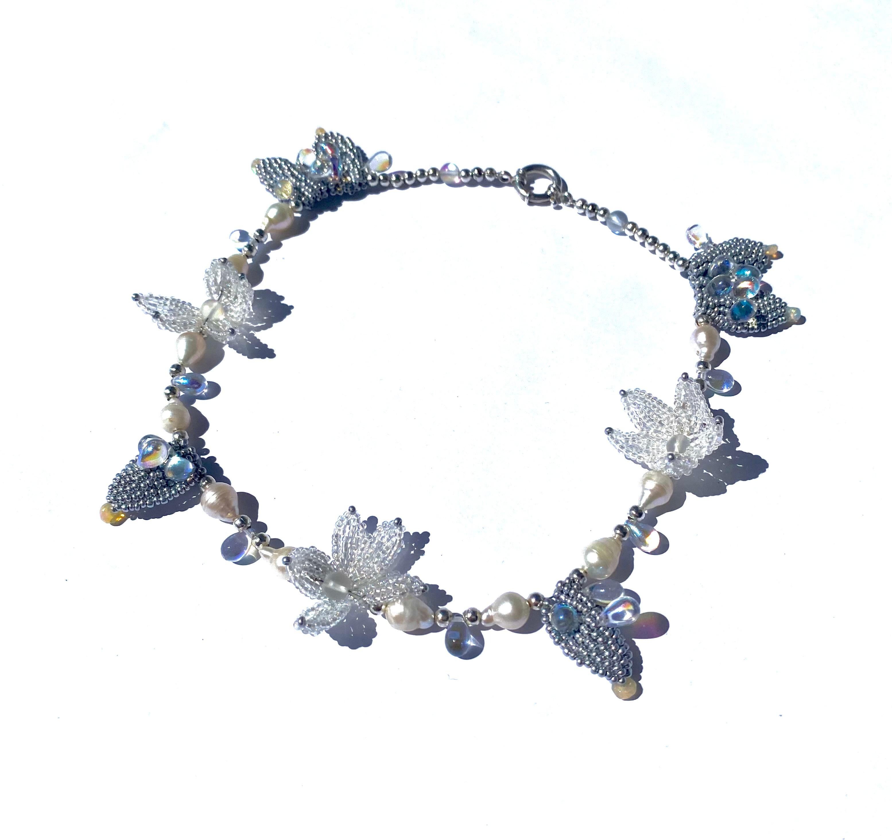 Handwoven iridescent beaded sculptural flower shapes, silver matte handwoven leaves decorated  with opal glass tear shape bead embroidery and authentic Ethiopian Opal fair trade beads tips, fresh Edison Pearls and quartz positioned in the most