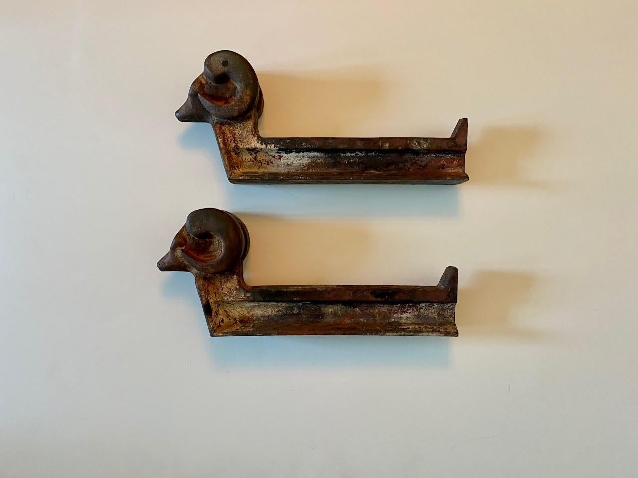 Incredible and bold 1930s examples of andirons. Ram’s head form created in iron marked “Olympic Log Master” on side. Powerful pieces.