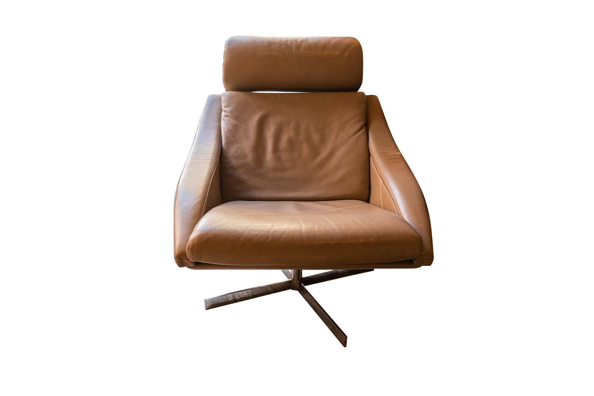 Design A&M pour Roche Bobois,
Chaise pivotante Bakea, appui-tête réglable,
Cuir taupe, pied en acier chromé et coque en bois,
Cachet du fabricant,
France, vers 2000.

Dimensions : Largeur 78 cm, profondeur 90 cm, hauteur 85 cm.