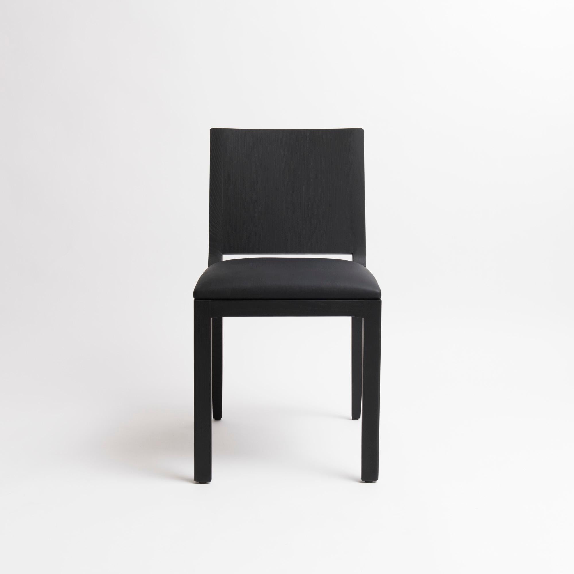 Minimal modern design chair by Parisian based studio mjiila. The om5.1 is a contemporary upholstered high-end chair handcrafted by skilled cabinetmaker. Available in black stained ash, matte varnish finish, upholstered with premium black leather.