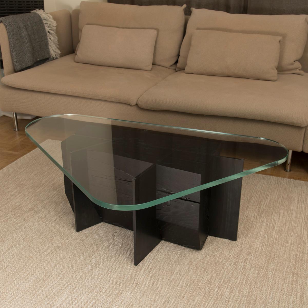 Carved from a single piece of solid 50 years old oak, pierced by patinated steel, the om6.0 coffee table base is a primitive sculpture left exposed by the heavy 19 mm thickness tempered extra-clear organic shape glass top.
Designed by Olivier