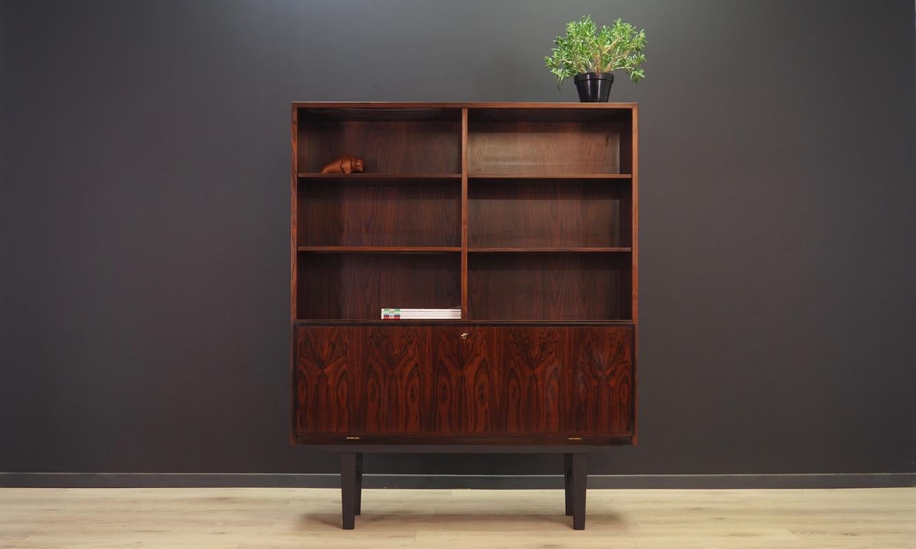 Classic bookcase - library from the 1960s-1970s. Scandinavian design, minimalist form. The bookcase is manufactured by Omann Jun. Furniture finished with rosewood veneer. Shelves adjustable in height, drawers inside the bar with lighting. Maintained