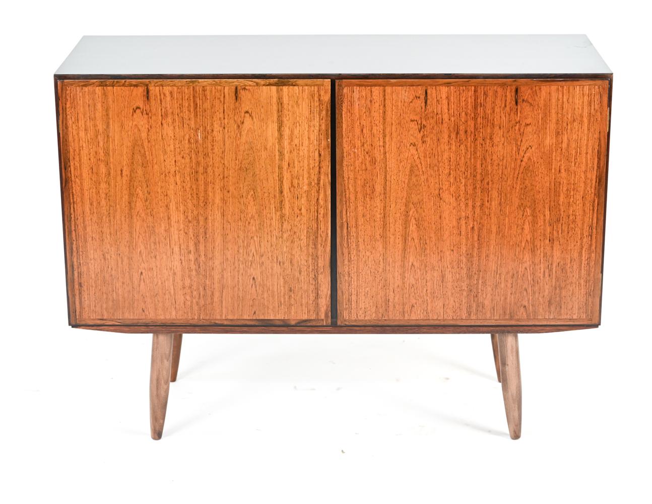 A handsome Danish mid-century rosewood cabinet with attractive shiny black laminate top by Oman Jun.