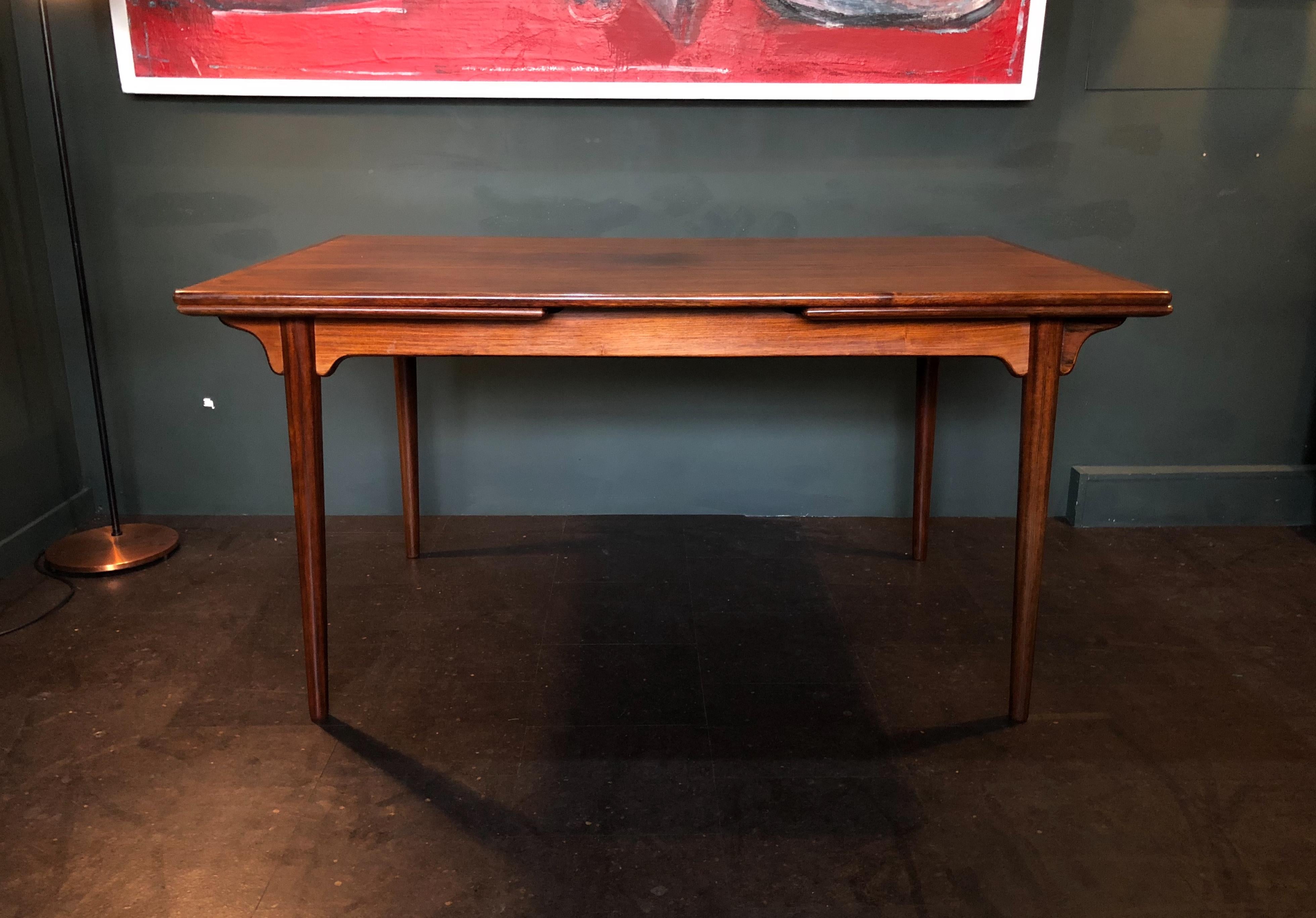 Danish Midcentury rosewood dining table designed by Gunni Omann for Omann Jun, Denmark, 1960s. This table has two pull-out extending leaves to a maximum of 251cm. The table surfaces have been refurbished and finished in traditional Danish oil. A