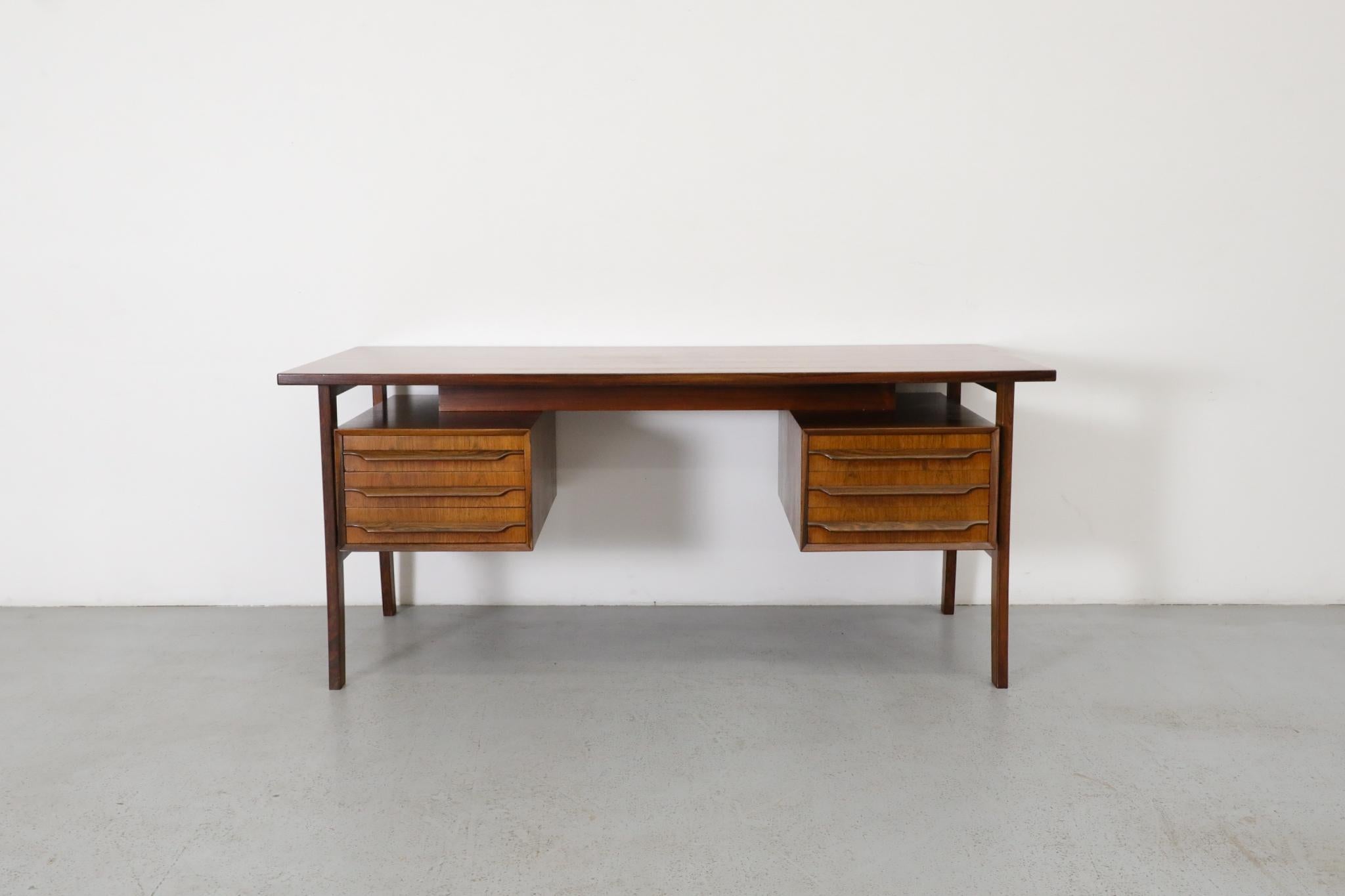 Mid-Century executive rosewood desk with floating top and two side cabinets, each with three drawers. Drawers measure 17.25