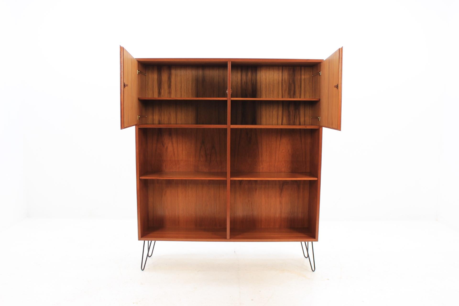 This Danish teak cabinet/bookcase features two doors compartment with inner two shelves and two outside shelves.All of them adjustable. This item was carefully restored.