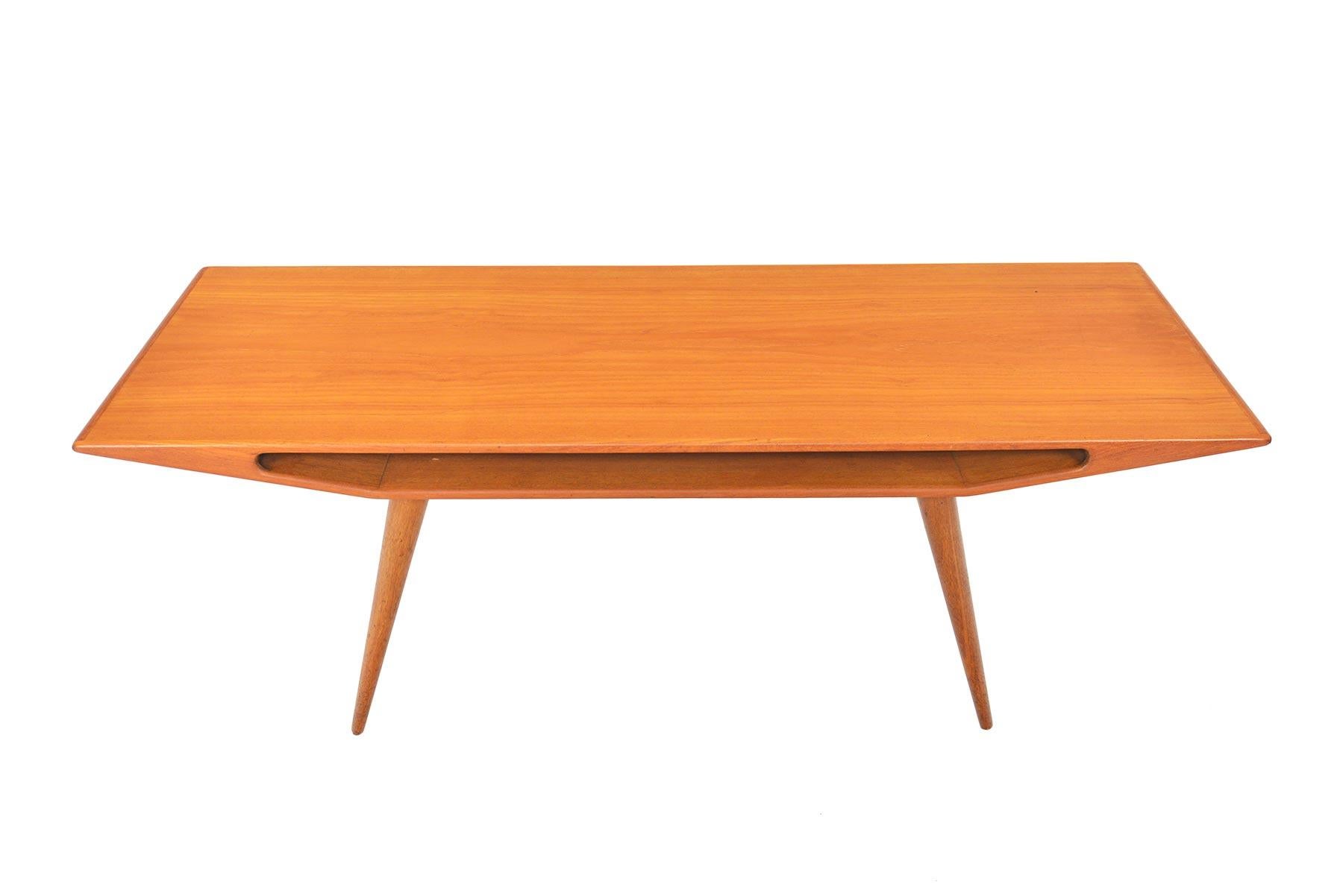 This stunning coffee table was originally designed as model 100 by Omann Jun for Omann Jun Møbelfabrik in 1953. Table top features a lower cubby and canted teak legs. Recently refinished and in excellent condition.

  