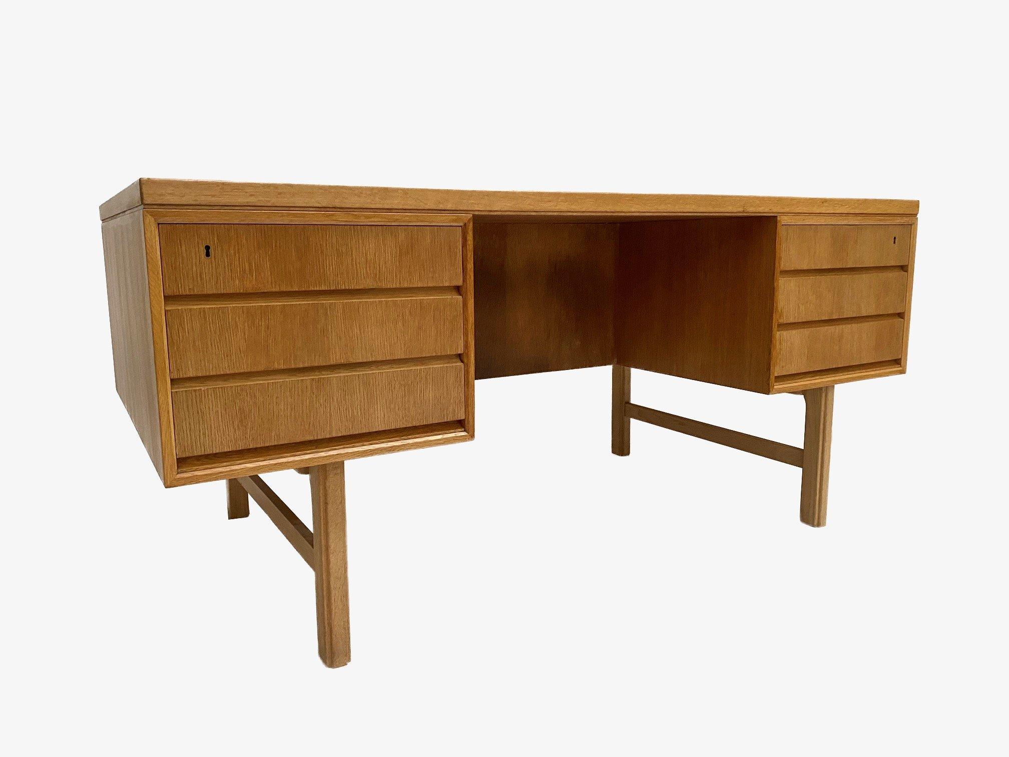A beautiful Danish Model 76 oak desk designed by Gunni Omann for Omann Jun Møbelfabrik in the 1960s, this would make a stylish addition to any work area. A striking piece of classically designed Scandinavian furniture.

The desk has two banks of