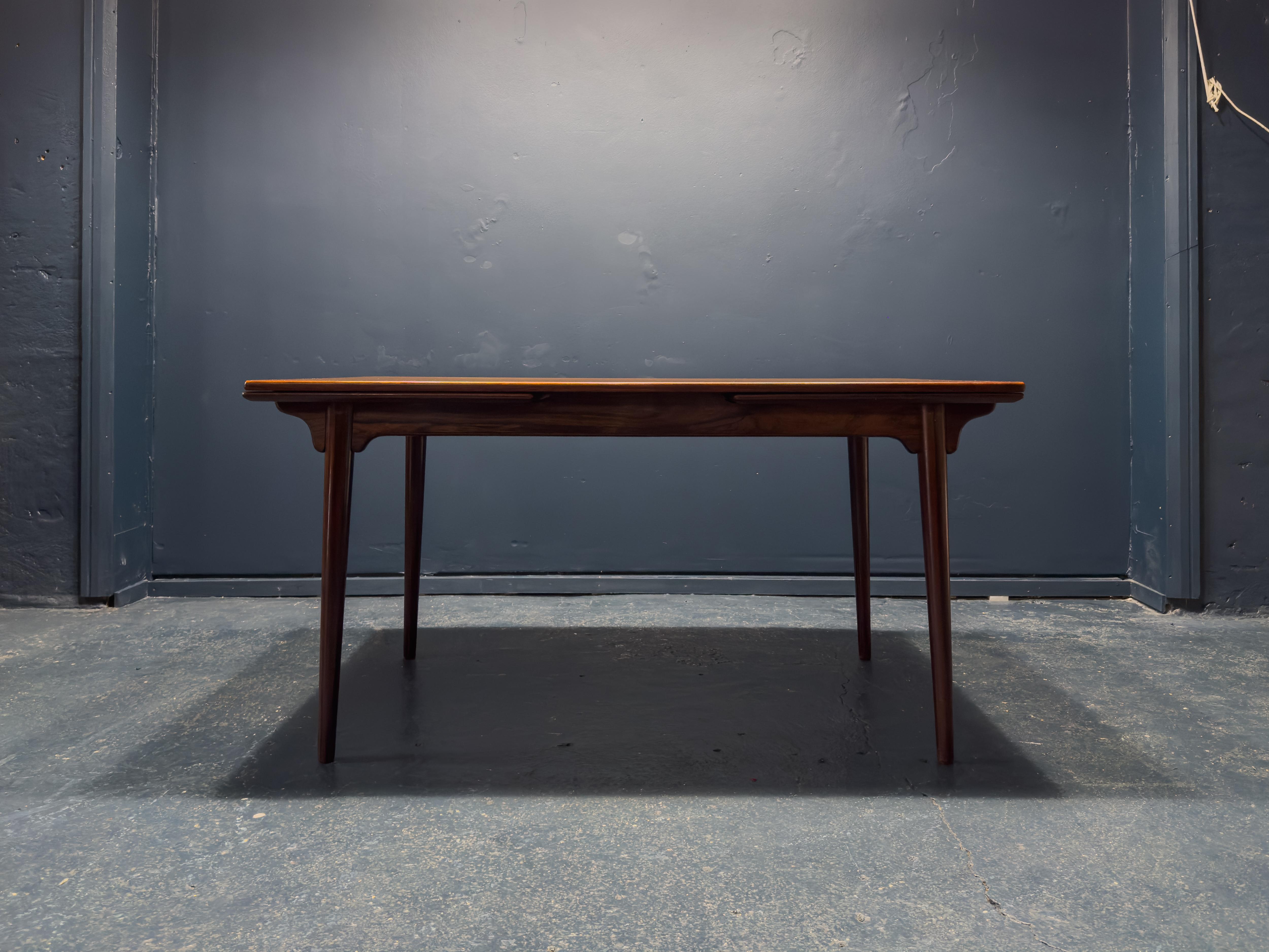 Fabriquée par Design/One dans les années 1960, cette incroyable table de salle à manger est magnifiquement fabriquée, avec une fonctionnalité sans faille et un design élégant. Fabriquée en bois dur, la table présente une coloration riche et un grain