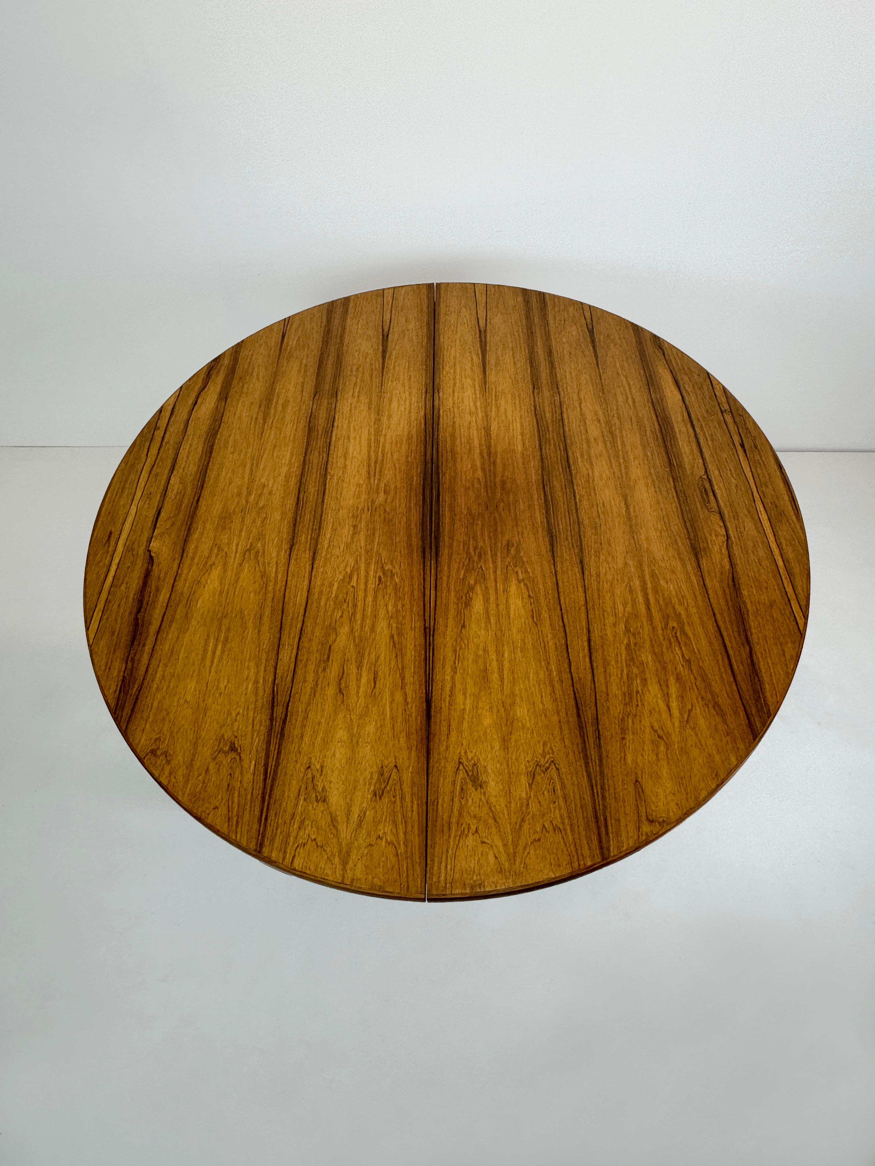 Vintage Danish Omann Jun round extendable Rosewood dining table, 1960s Danish modern round rosewood dining table with hidden double butterfly leaves. Extremely expressive and beautiful palisander grain pattern. Cleverly designed table where the