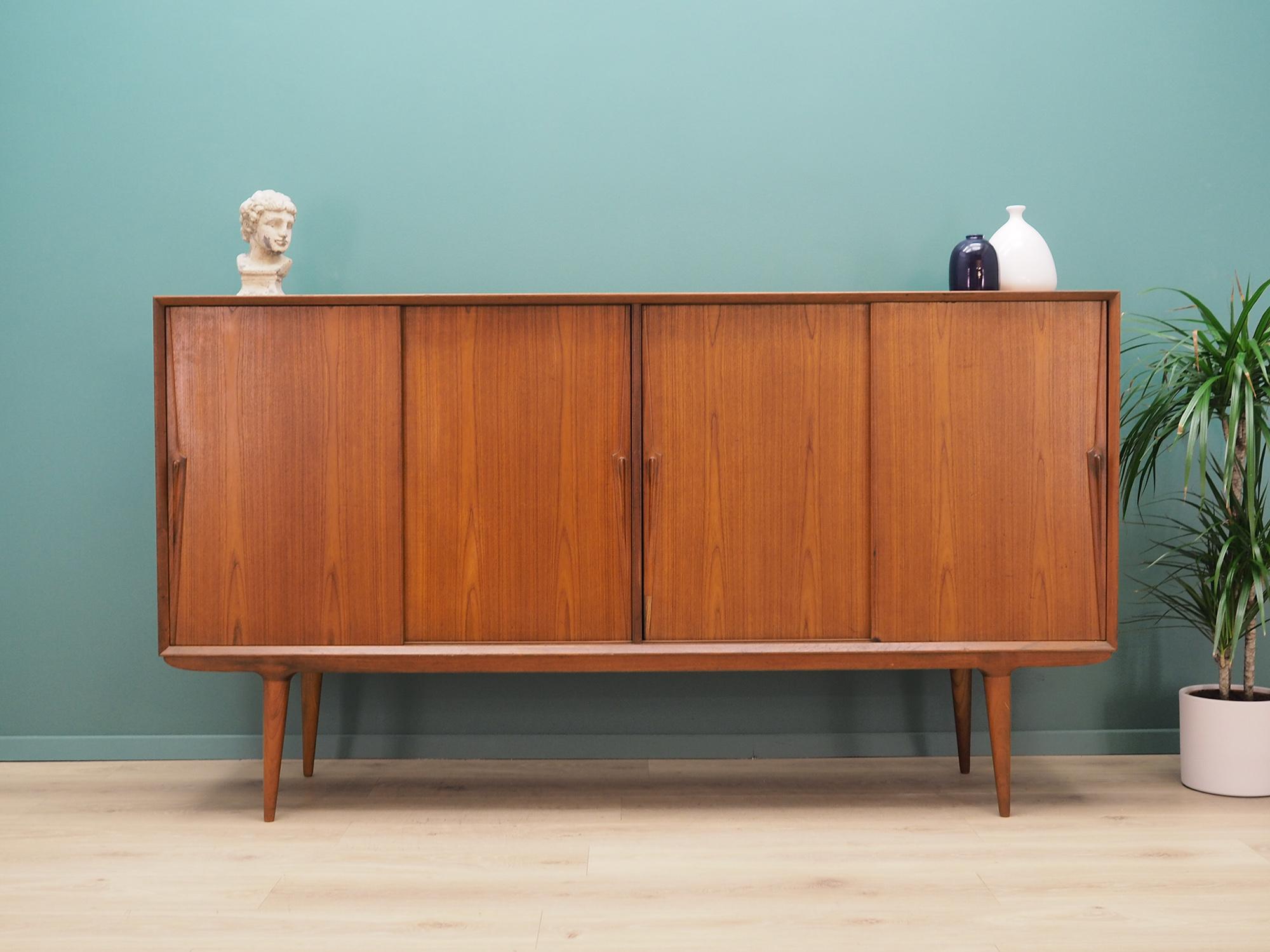 Superb high board from the 1960s-1970s. Minimalist form, Scandinavian design. Furniture is covered with teak veneer, legs are made of solid teak wood. Manufactured by Omann Jun. High board has five shelves and six stylish drawers. Preserved in good