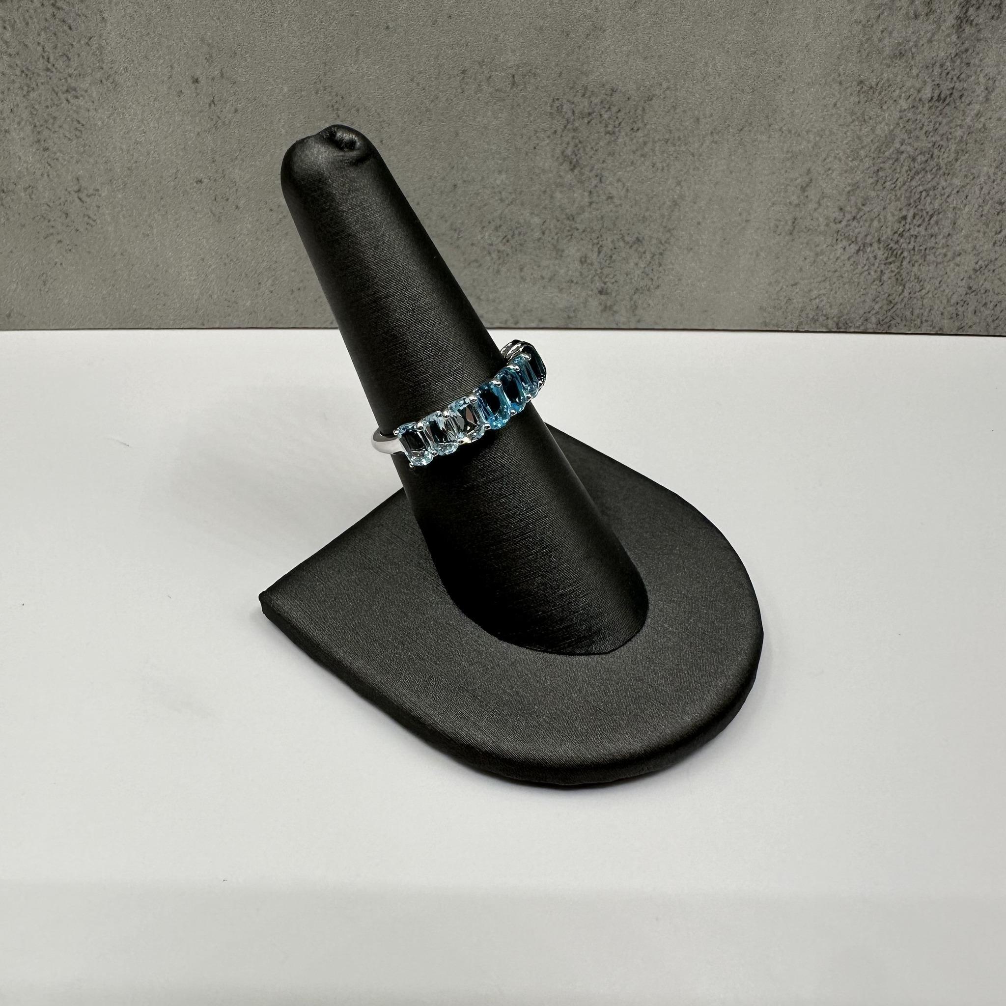 Cette magnifique bague en argent sterling ornée d'une topaze bleue en forme d'ombre présente une topaze bleue ovale d'environ 4,9 x 2,6 mm dont les tons dégradés passent d'un bleu clair à un bleu profond. La monture en argent sterling poli rehausse