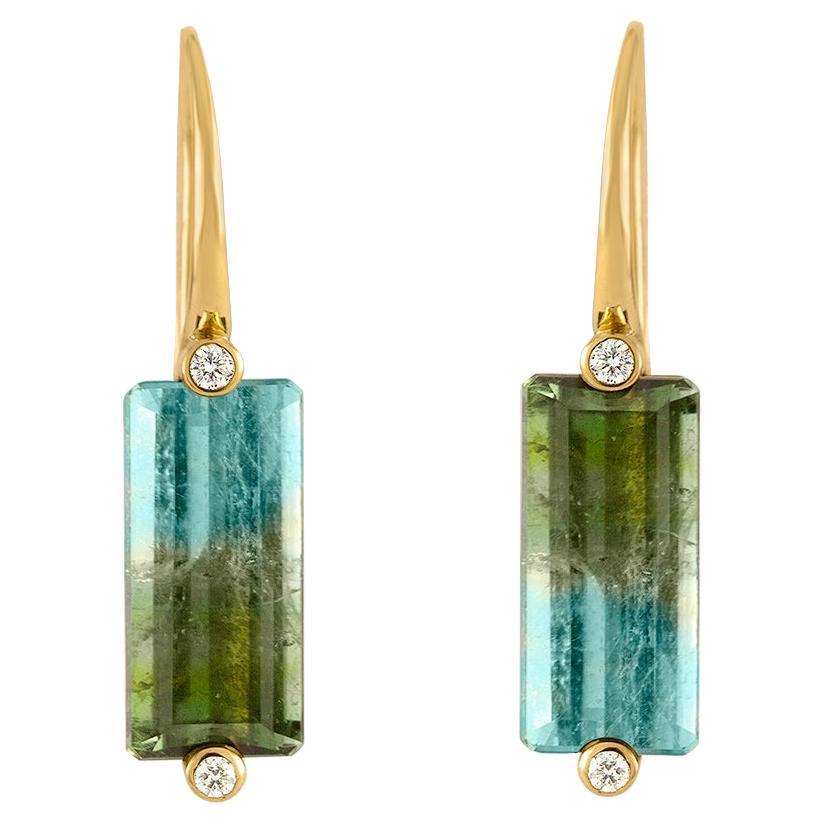 Aqua blue to grass green bi color tourmalines with defined color banding are set in opposite directions, each stone held in our signature Bi-Setting design by two diamonds north and south. Hand forged 18K yellow gold ear wires lend a sleek, balanced