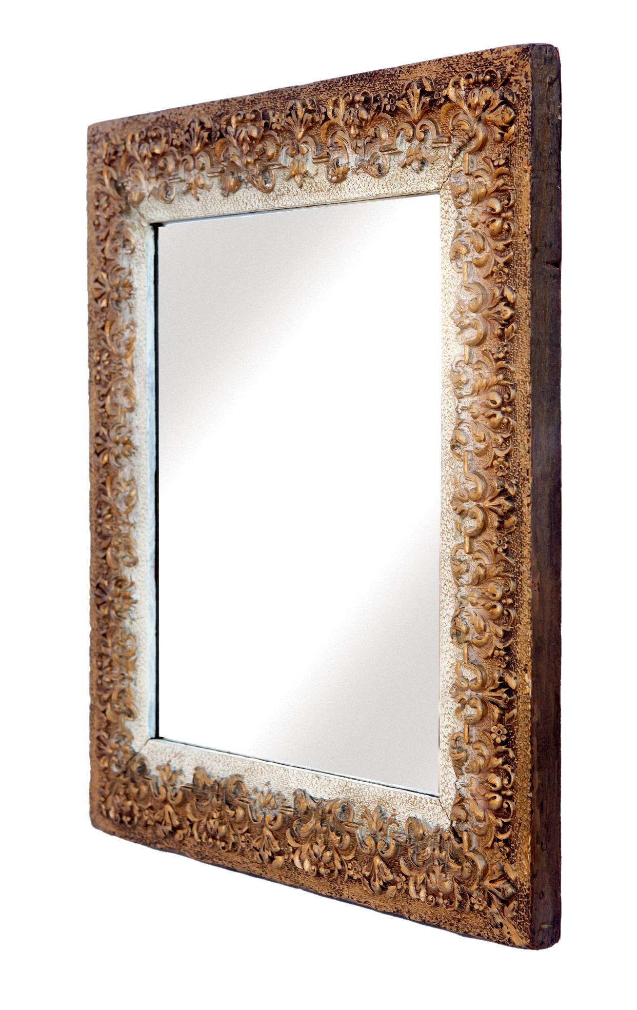 This mirror has a very fine and intricate repeat pattern of leaves flowers and scrolls offset by a textured cream background. The dark tones on the exterior border leads the eye in toward the center and whatever is reflected in the glass. New