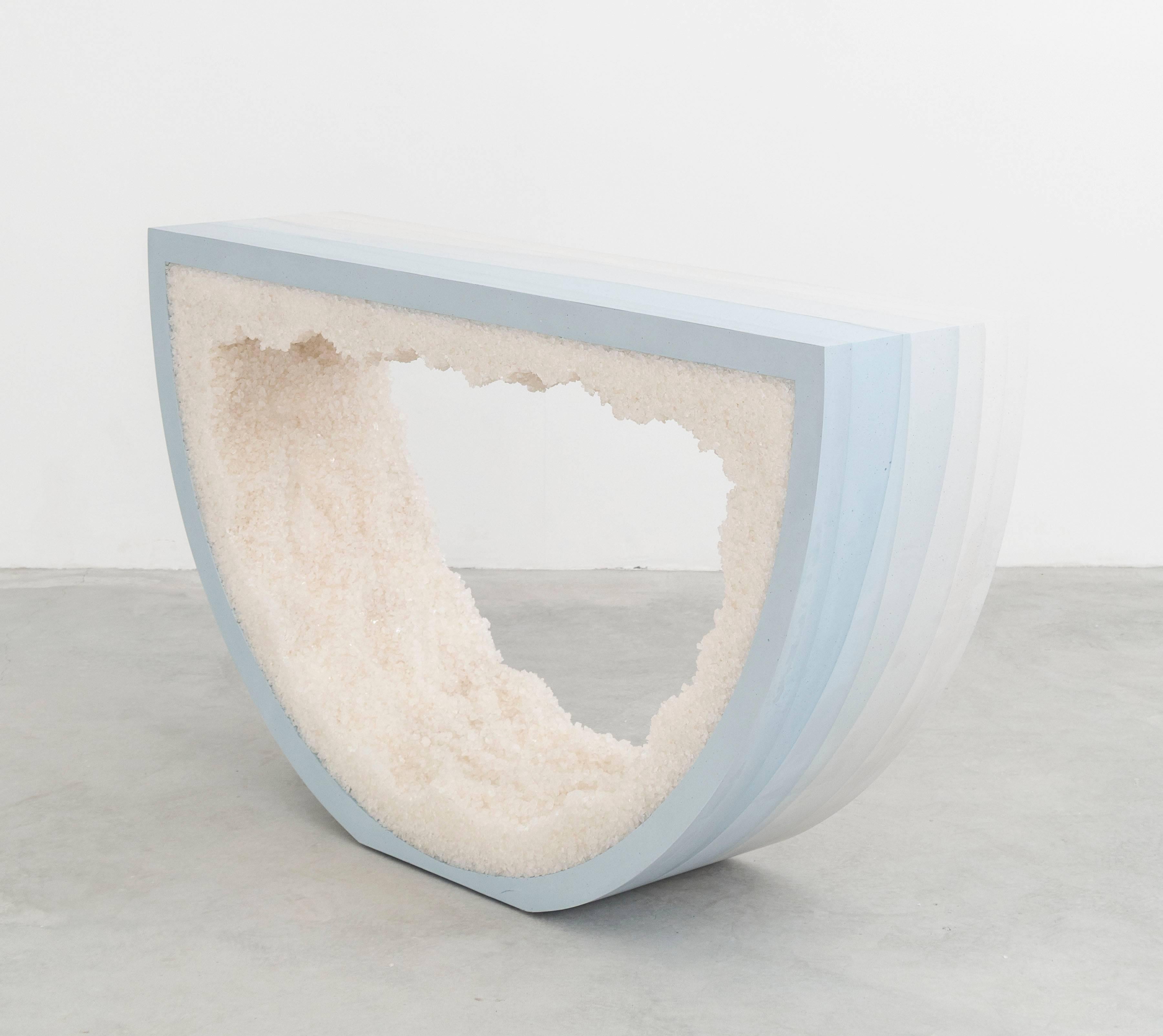 Composed from a combination of materials, the semicircle console consists of a hand-dyed white cement exterior and a rock salt interior. Packed by hand within the smooth ombre of sky blue cement, the white rock salt forms an organic texture to