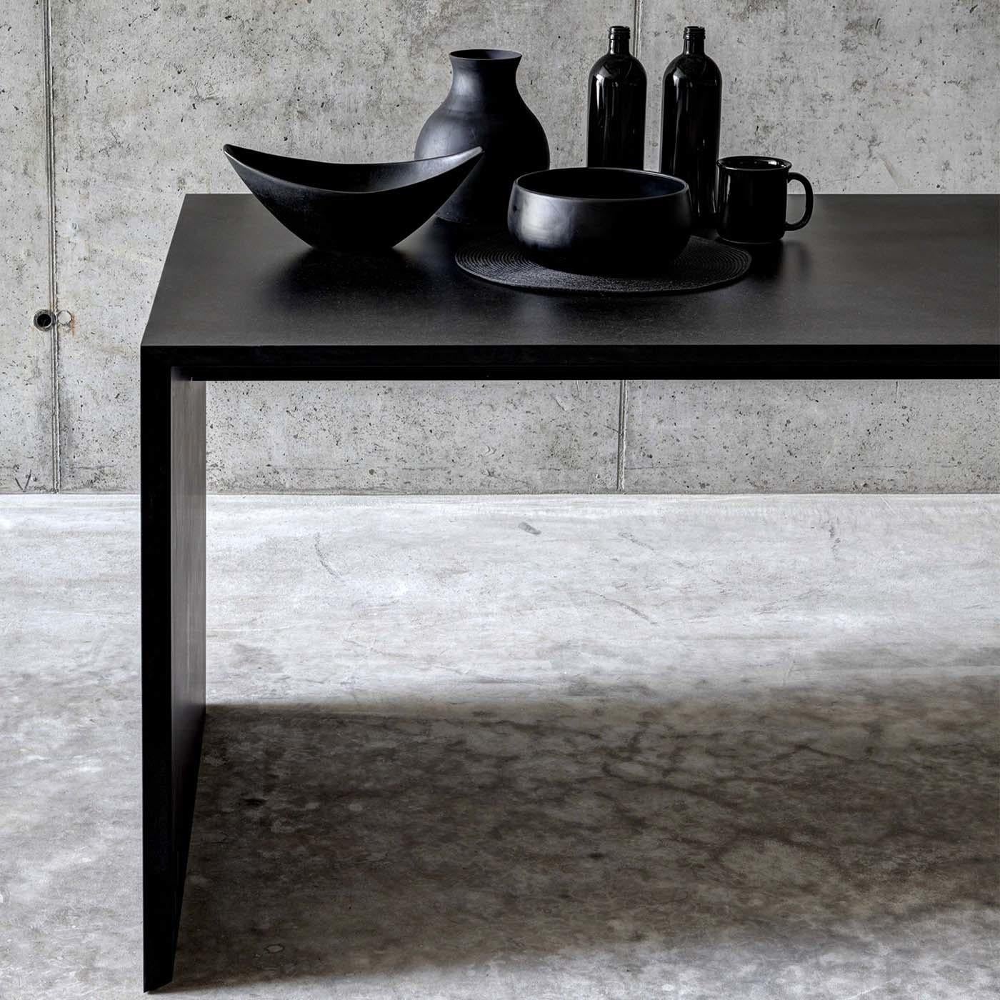 Part of the Ombrì collection designed by Studio Guscetti, this unique table is a superb choice for a contemporary interior. Its MDF structure is dyed with a black paste color with a matte finish. Its minimalist silhouette features 45-degree joints