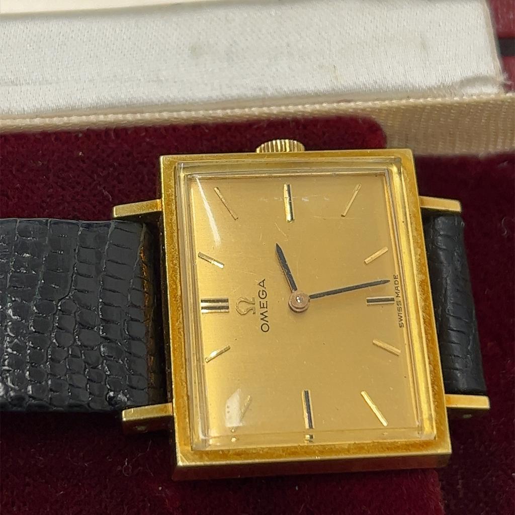 Vintage Omega 18ct yellow gold rectangle case with black leather crocodile strap.
(The glass has a few scratches)
In full working condition, with the original box.

Total Weight of Watch: 22.2g
Case size: 26mm x 21mm
Movement: 620
Reference number: