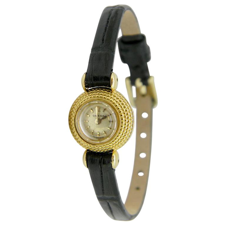 18kt yellow gold beehive detail ladies wristwatch. This sweet 1957 cocktail watch features a petite dial with a diameter spread of 10.5mm and total case diameter of 15.5mm. The glass is domed and slightly bevelled with a white face and gold hands