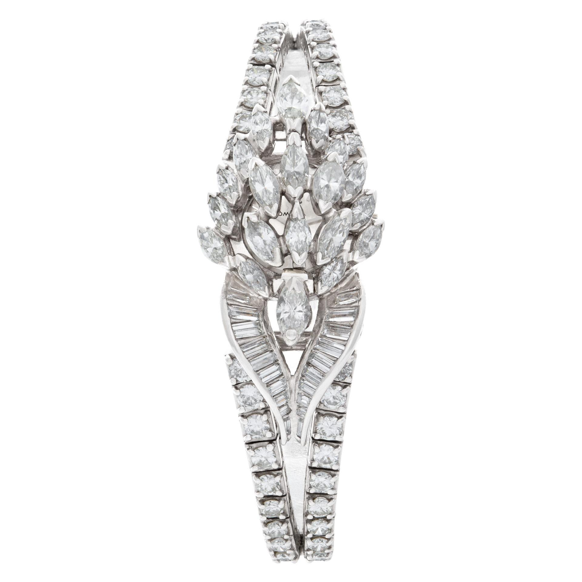 Vintage Omega watch in platinum with 10 carats in round, baguette & marquise diamonds. Pushing the spring loaded cover reveals the omega cocktail watch. Manual wind. 17 mm case size. Watch fits 6 inch wrist. Fine Pre-owned Omega Watch. Certified