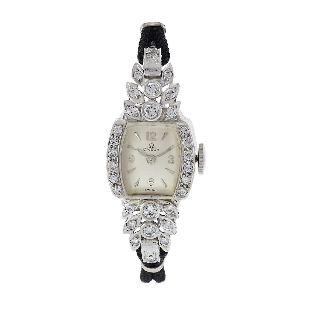 Elegance and history converge in this vintage Omega ladies' diamond watch from the 1950s. Encased in a petite 12x34mm platinum and diamond-studded case and paired with a sleek black nylon strap, this timepiece is a true work of art. With a 17-jewel