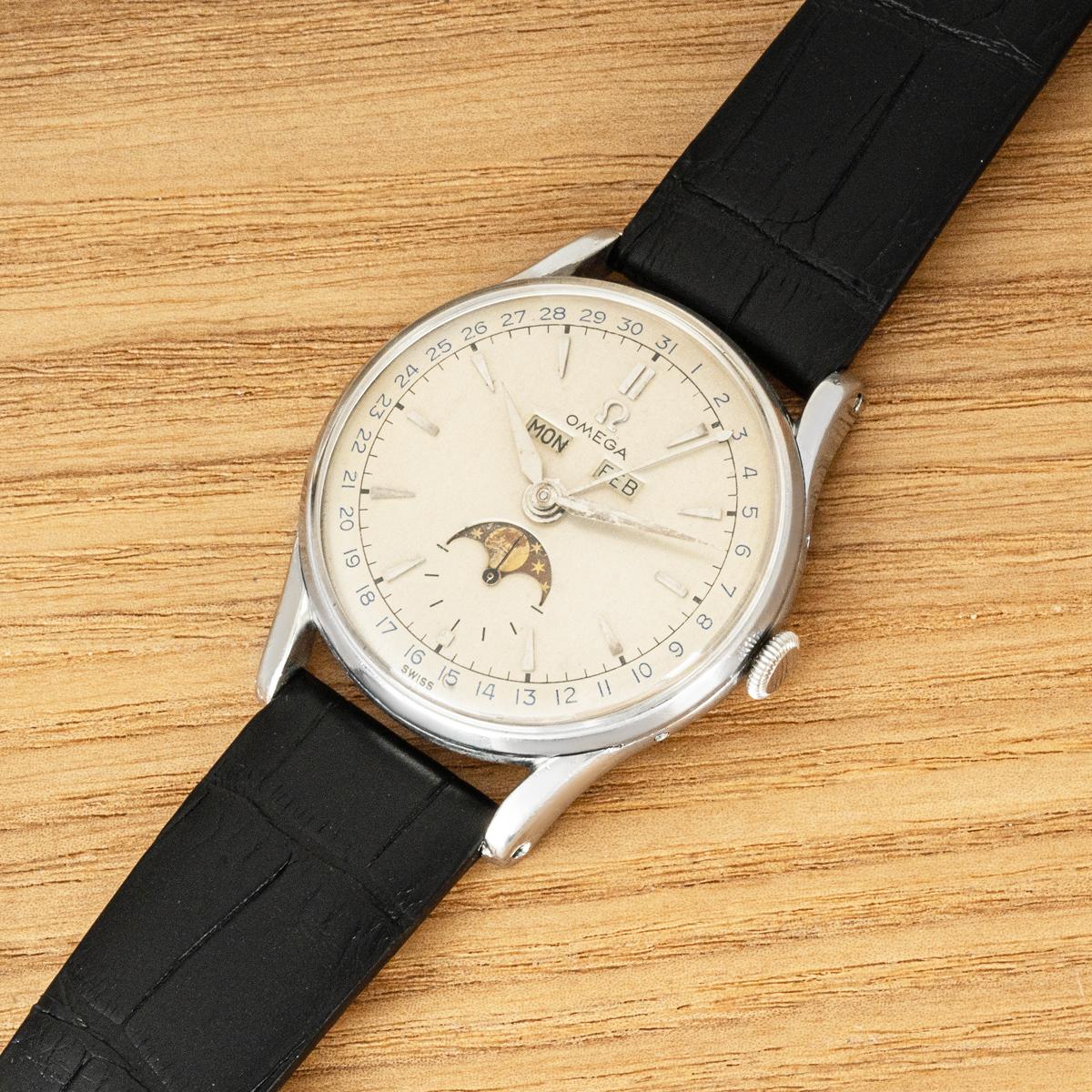 A 35mm vintage Cosmic Moonphase triple date calendar by Omega in stainless steel. Features a silver dial displaying the day, date and month as well as a moon phase indicator. Fitted with plastic glass, a manual winding movement and a generic black