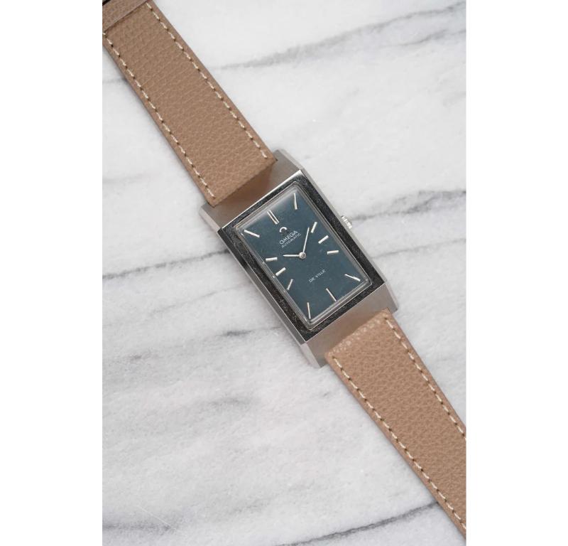 Ecco un Omega de Ville automatico d'epoca con quadrante blu con effetto sunburst degli anni '70. Tiene benissimo il tempo ed è perfettamente funzionante. Le misure includono una cassa quadrata di 34 mm e una larghezza delle anse di 20 mm. Il