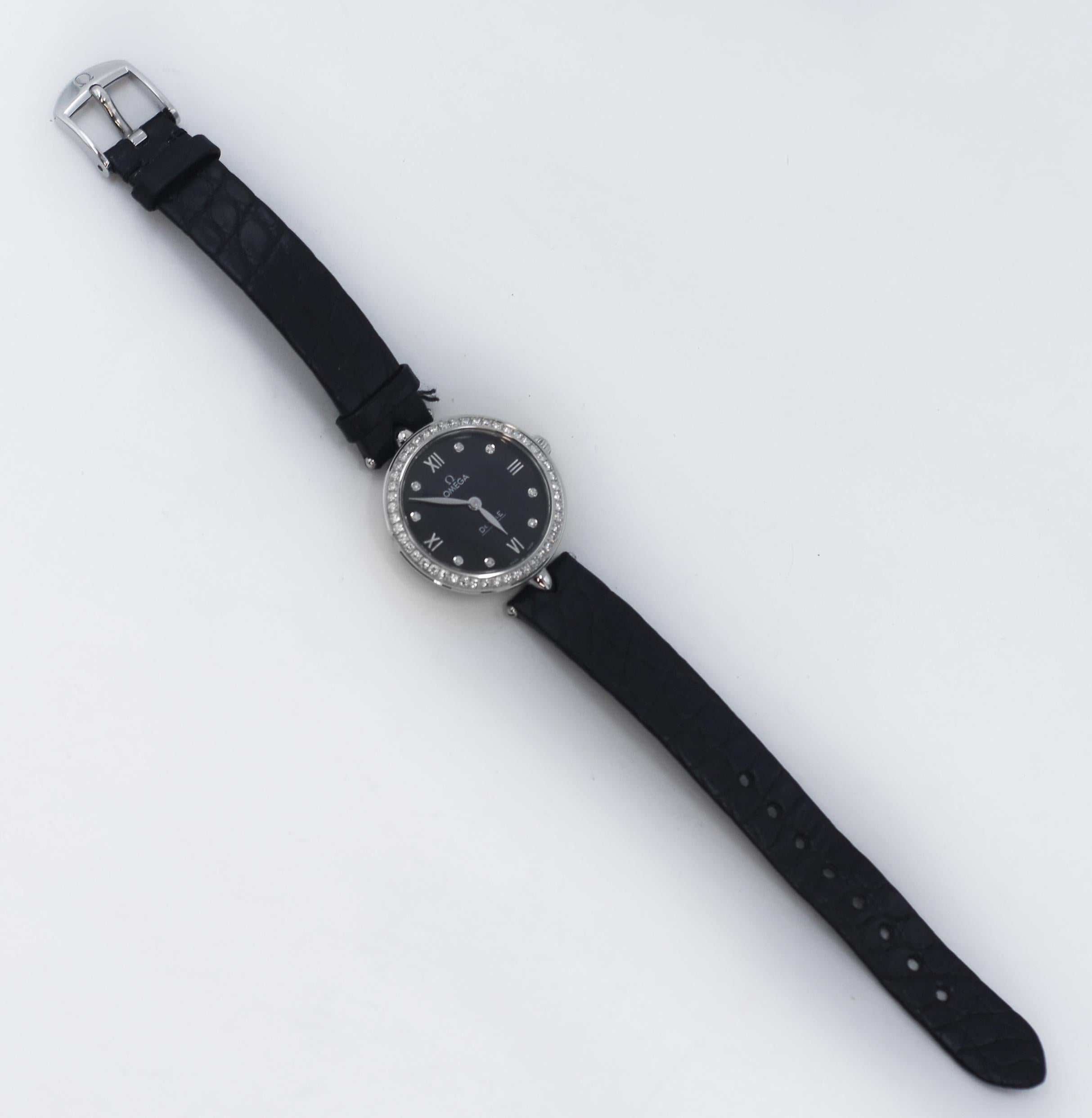 OMEGA De Ville Prestige Watch 
In Silver-tone stainless steel case with a black leather pattern strap. 
Fixed Single row Diamond silver-tone stainless steel bezel. 
Black dial with steel hands and diamond hour markers along with steel Roman numerals