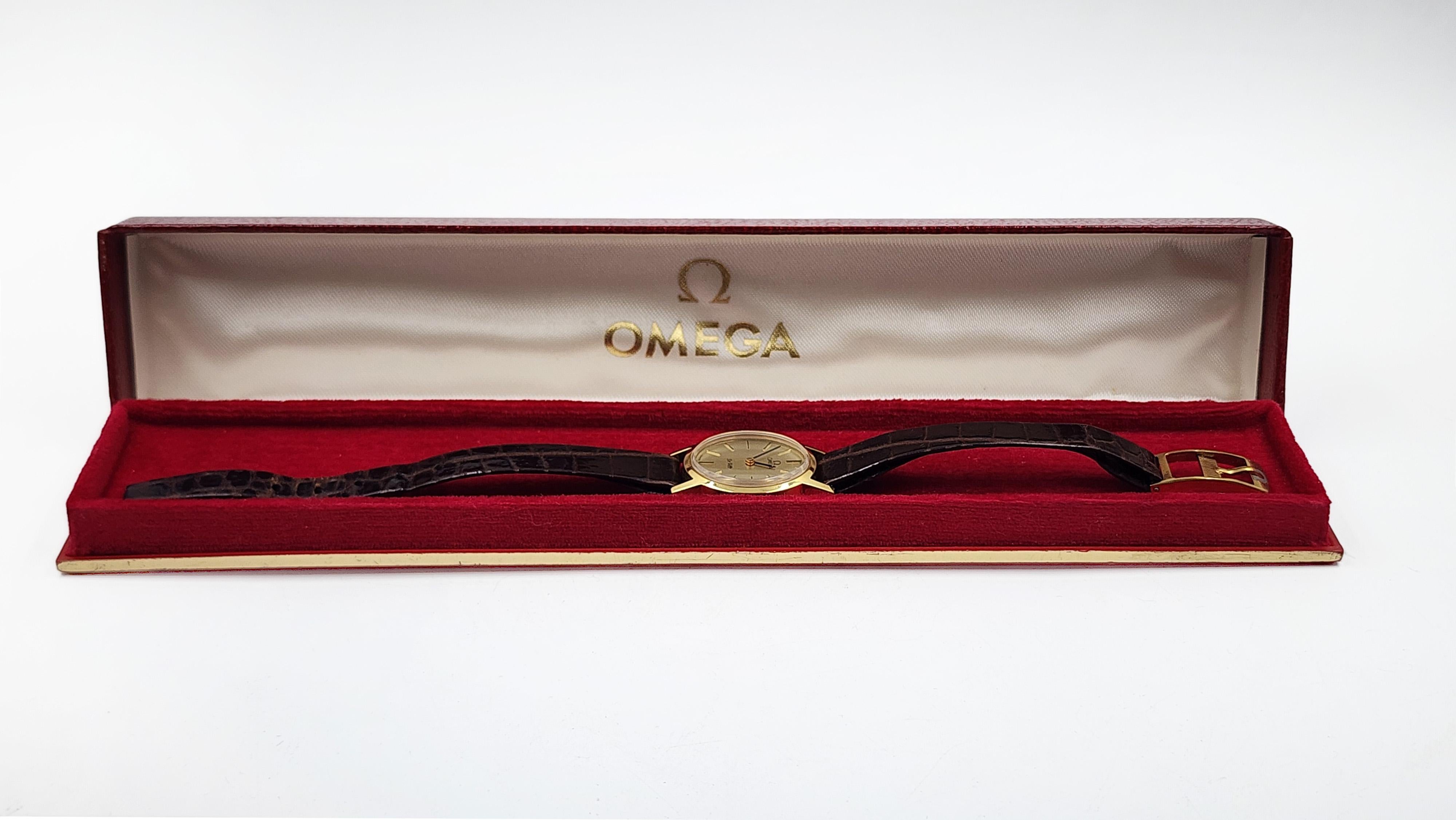 Montre femme Omega De Ville Vintage 1960s
Cette montre Omega De Ville vintage pour femme, datant des années 1960, présente un boîtier plaqué or et un fond en acier inoxydable. Son cadran doré est souligné par de fins index et aiguilles noirs pour
