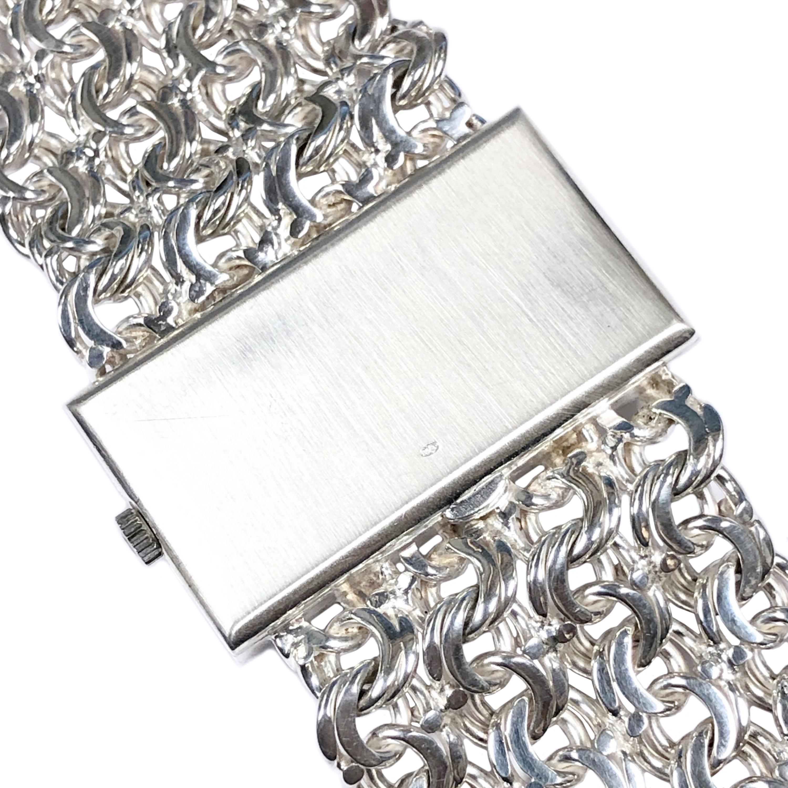 Circa 1970 Omega De Ville Bracelet Watch, Sterling Silver 2 piece Case measuring 1 1/2 X 3/4 inch, attached sterling Silver very soft and flexible link bracelet measuring 1 1/4 inch wide. Total watch length 7 1/2 inches. 17 Jewel Mechanical, Manual