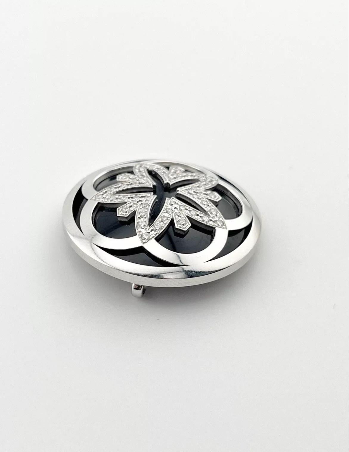 The OMEGA Flower Pendant 18K White Gold 0.37ct Diamonds Black Onyx is a stunning blend of elegance and artistry. Crafted in luxurious 18K white gold, this pendant features a delicate flower design, with each petal set with sparkling diamonds