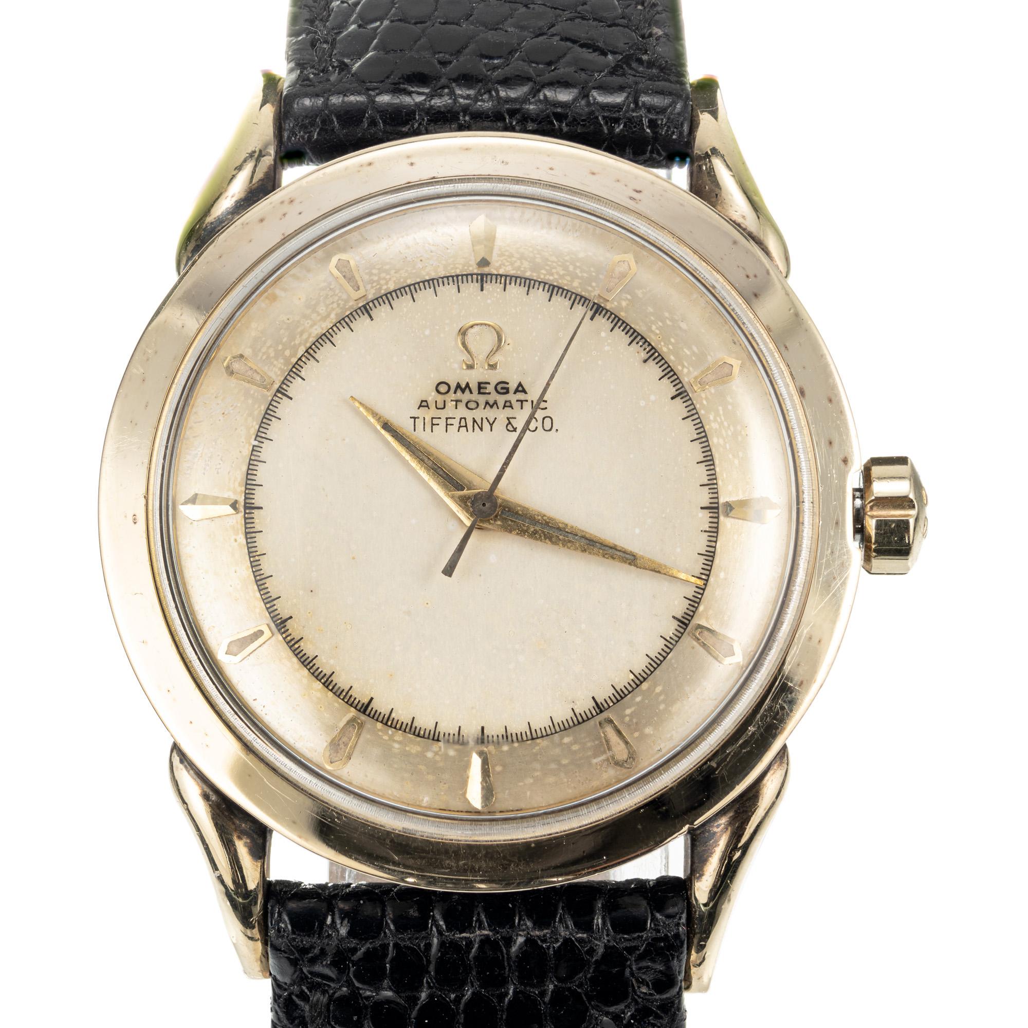 Omega Armbanduhr mit vergoldetem Gehäuse und Edelstahlboden, verkauft von Tiffany & Co,  Ref. 351, ca. 1960er Jahre, mit automatischem Stoßdämpferwerk. Lünette aus 14er Gelbgold und Boden aus Edelstahl.

Länge: 42,51 mm 
Breite: 33 mm 
40.0