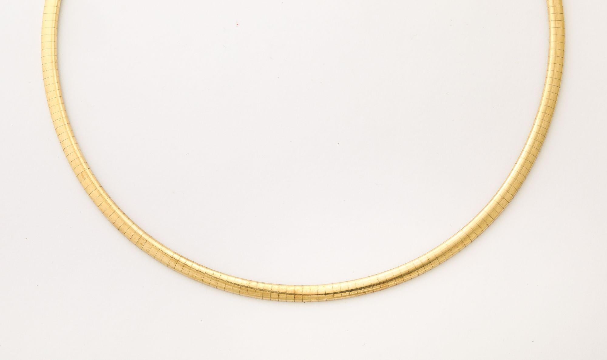 Se trata de un collar Omega vintage de oro, caracterizado por su diseño elegante, rígido y sofisticado de estilo gargantilla.
Está fabricado con placas o alambres metálicos firmemente unidos sobre una malla interior, lo que le confiere una