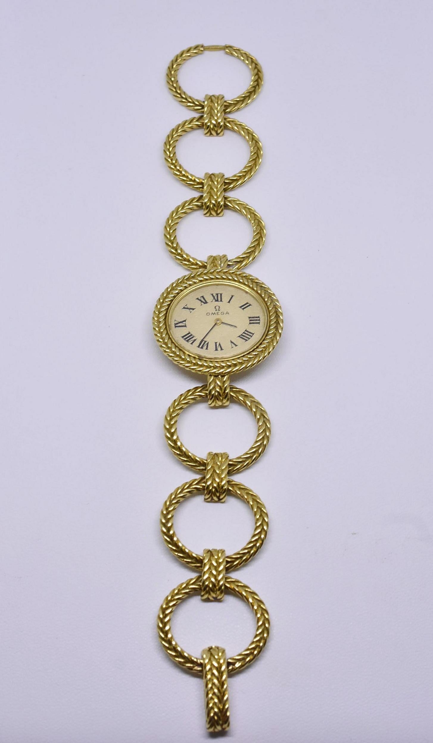 Beautiful ladies Omega 18-karat winding gold watch. This is an unusual watch with oval braided gold links making a bracelet. The dial is in excellent shape, the crystal has slight scratching due to age and use. Measures: 6 1/2