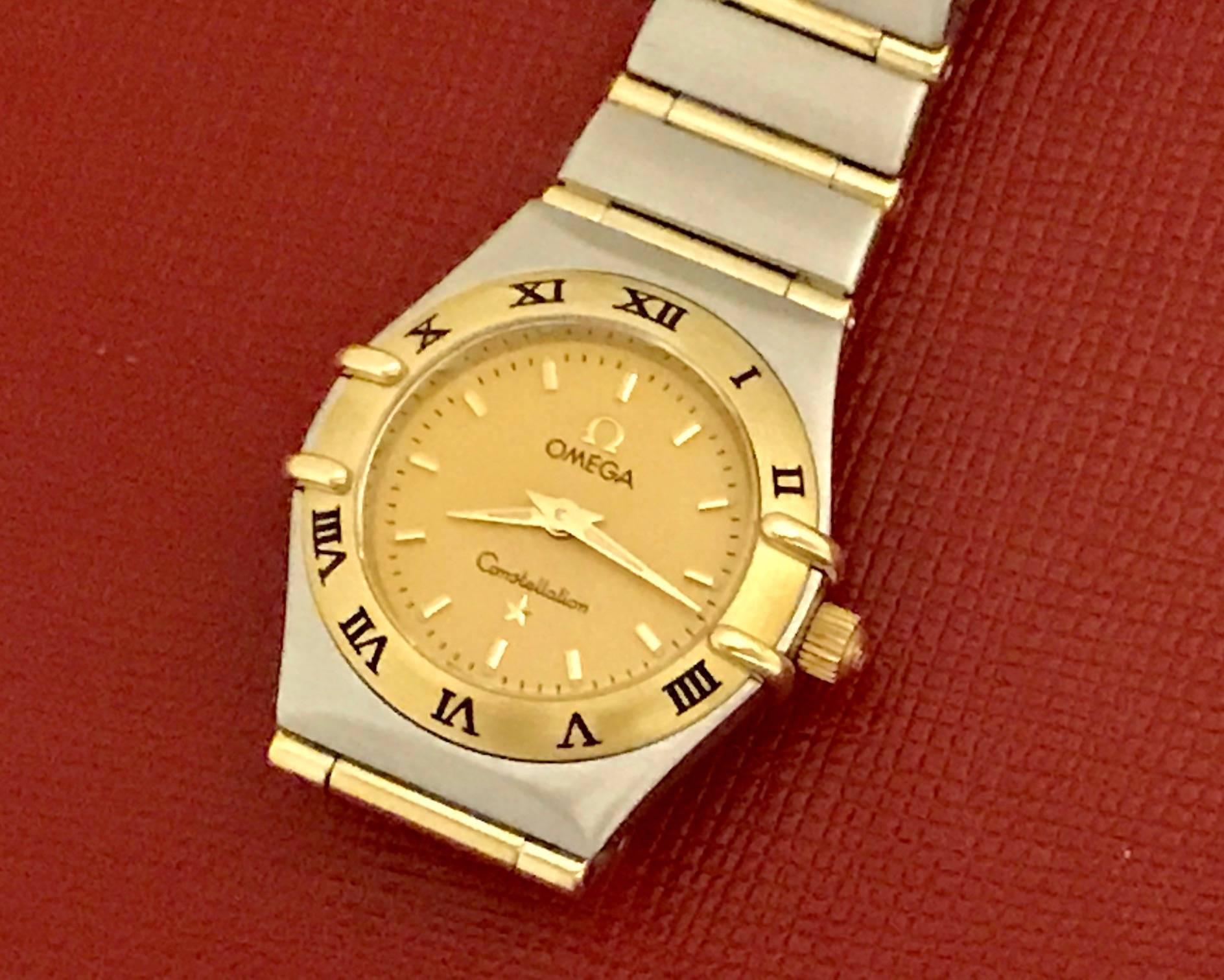 Omega Constellation ladies quartz pre-owned wrist watch. This beautiful classic Omega features a champagne dial with polished hour markers and classic stainless steel case with 18k bezel adorned with black roman numerals. Measures 23mm. This watch
