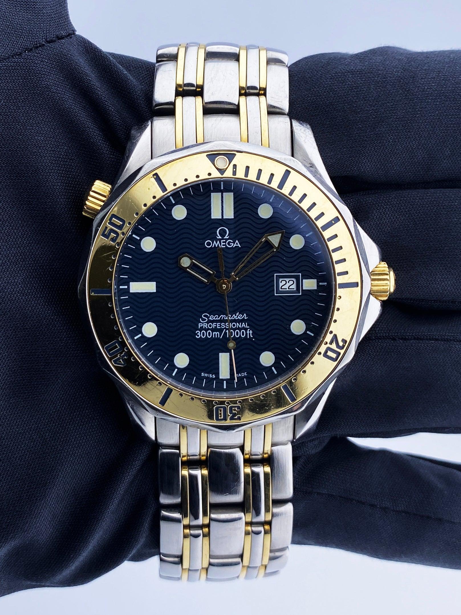 Omega Seamaster Mens Watch. 41mm stainless steel case. Stainless steel unidirectional rotating bezel with 18K yellow gold insert. Blue wave dial with luminous gold hands and luminous dot hour markers. Minute markers on the outer dial. Date display
