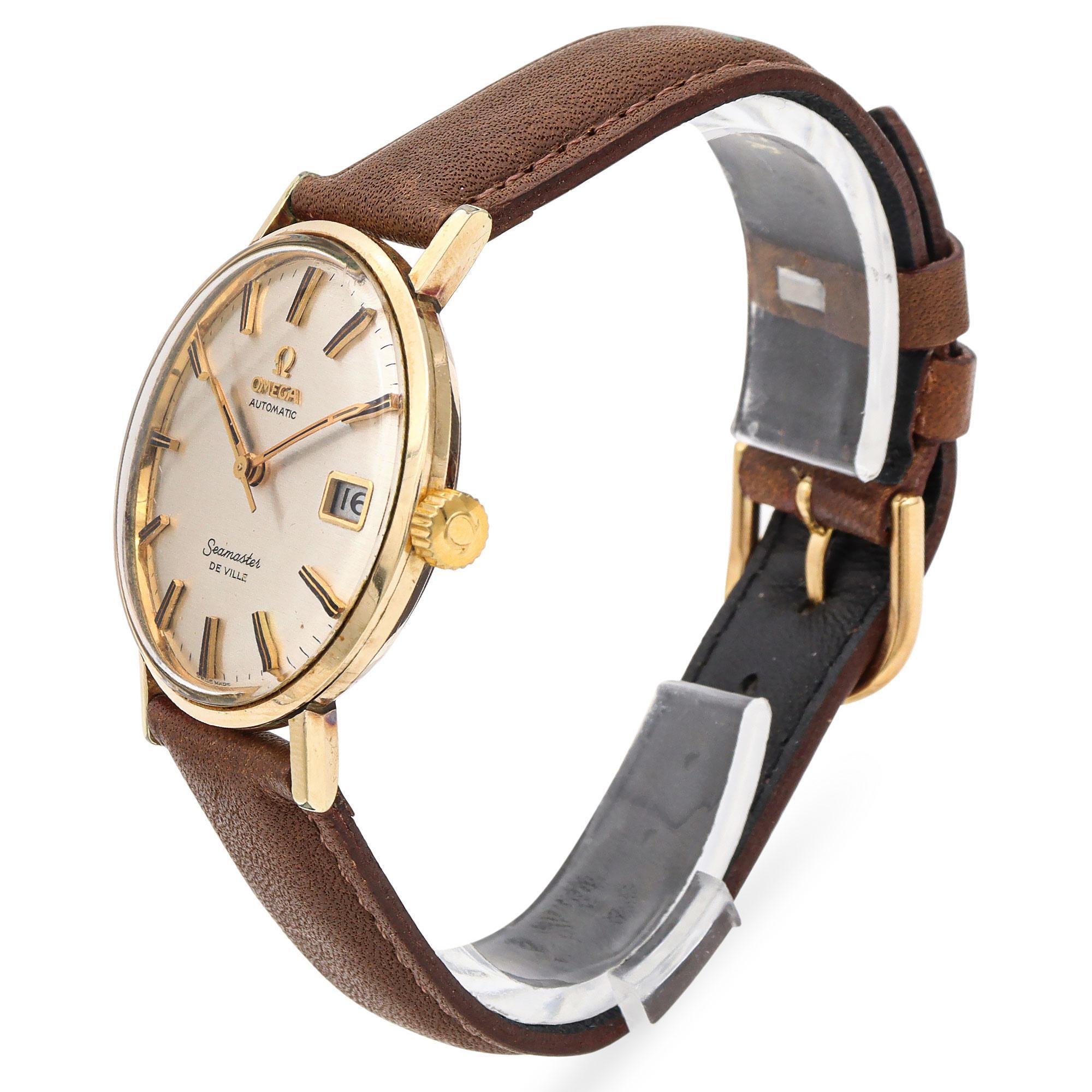 A classic Omega watch with automatic movement. Crafted in 14k gold, this elegant timepiece features a refined dial with a date indicator at the 3 o'clock position. The watch face is adorned with sleek hour markers and hands, exuding a timeless