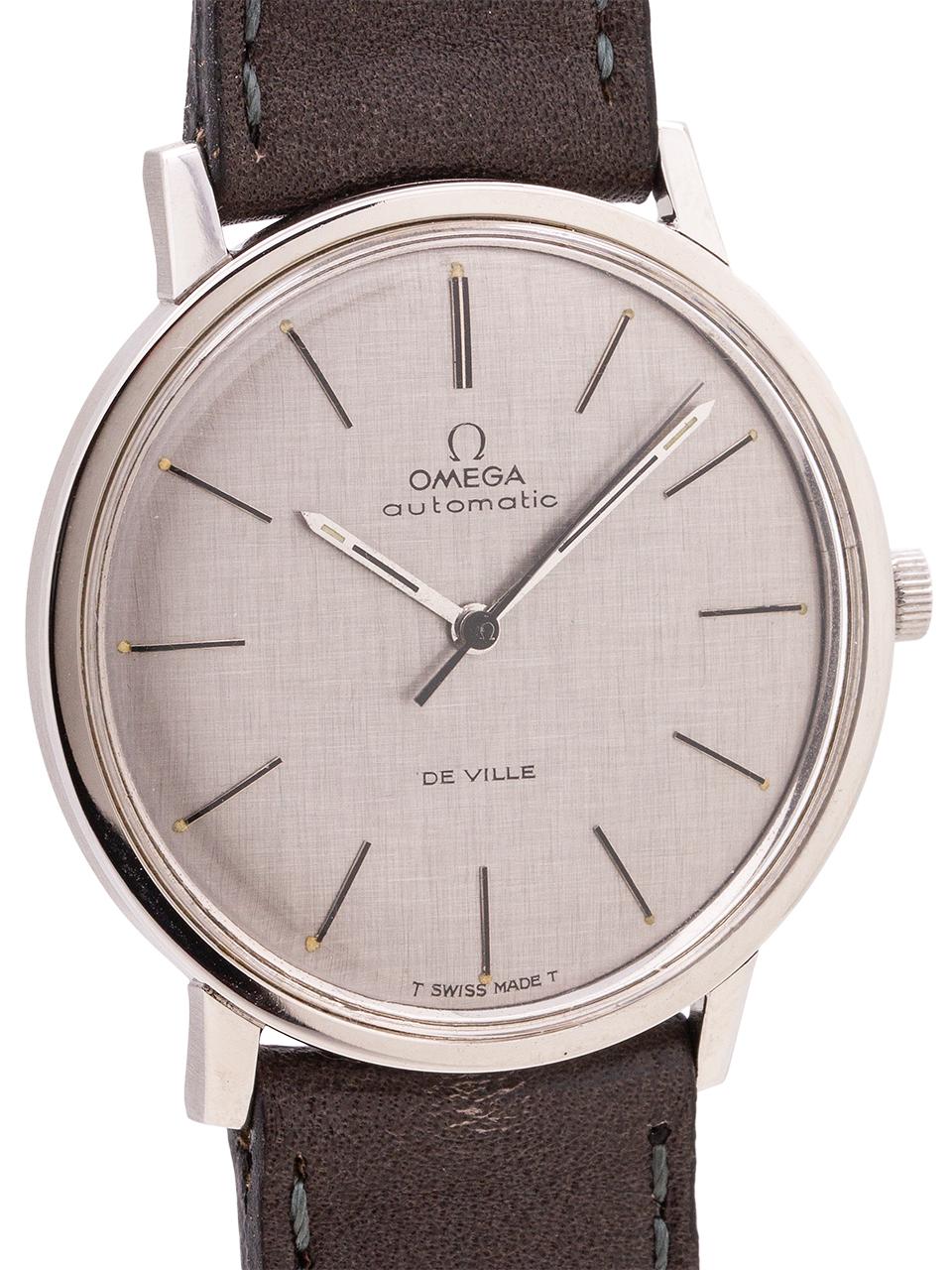 
Very dressy mid century design vintage man’s Omega stainless steel De Ville ref # 165.008 circa 1968. Featuring a sleek and slim 35 x 38mm case with screw down case back, acrylic crystal, and original finely linen textured matte silver dial with