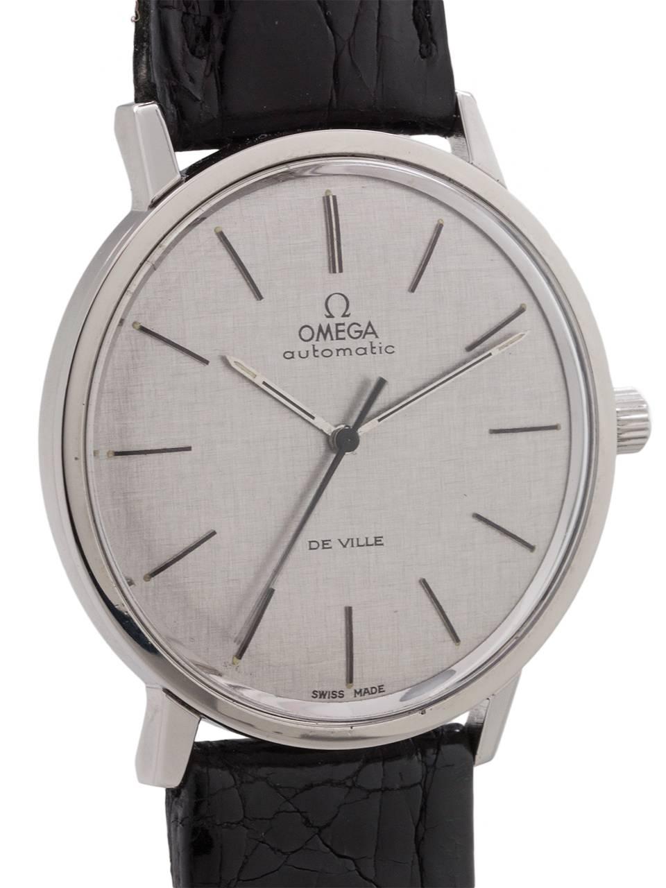 
Very dressy mid century design vintage man’s Omega stainless steel Deville ref # 165.008 circa 1968. Featuring a sleek and slim 35 x 38mm case with screw down case back, acrylic crystal, and original finely linen textured matte silvered dial with