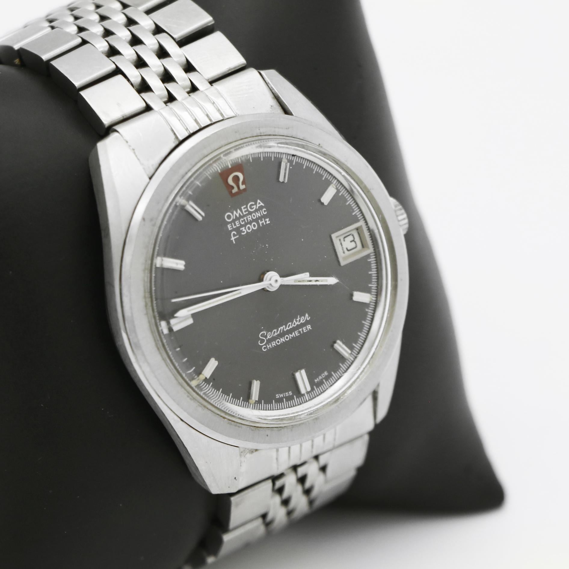 Omega
Electronic
f300 watch 
Gray Dial
steel numbers markers
White Second, minute and hour sweeping hands
Date Feature at 3 o'clock mark
Acrylic crystal
Movement Calibre: 1250
12 Jewels
Swiss Made
Case Approx. 36mm
Stainless Steel case and