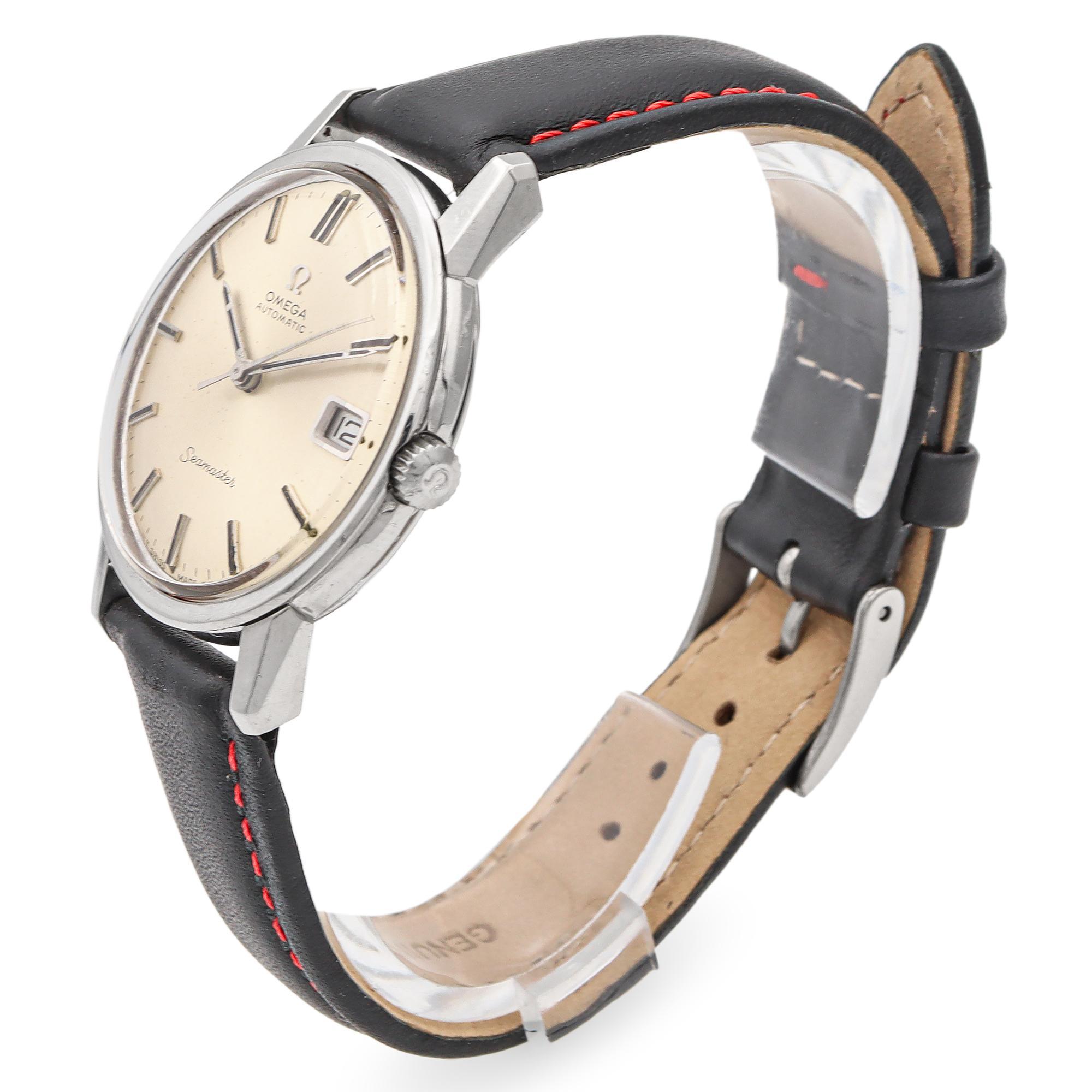 Vintage Omega Seamaster Automatic Watch. Crafted in stainless steel, this timepiece features a classic round dial with a date indicator at 3 o'clock. The watch showcases a clean, minimalist design with sleek hour markers and hands. The black leather