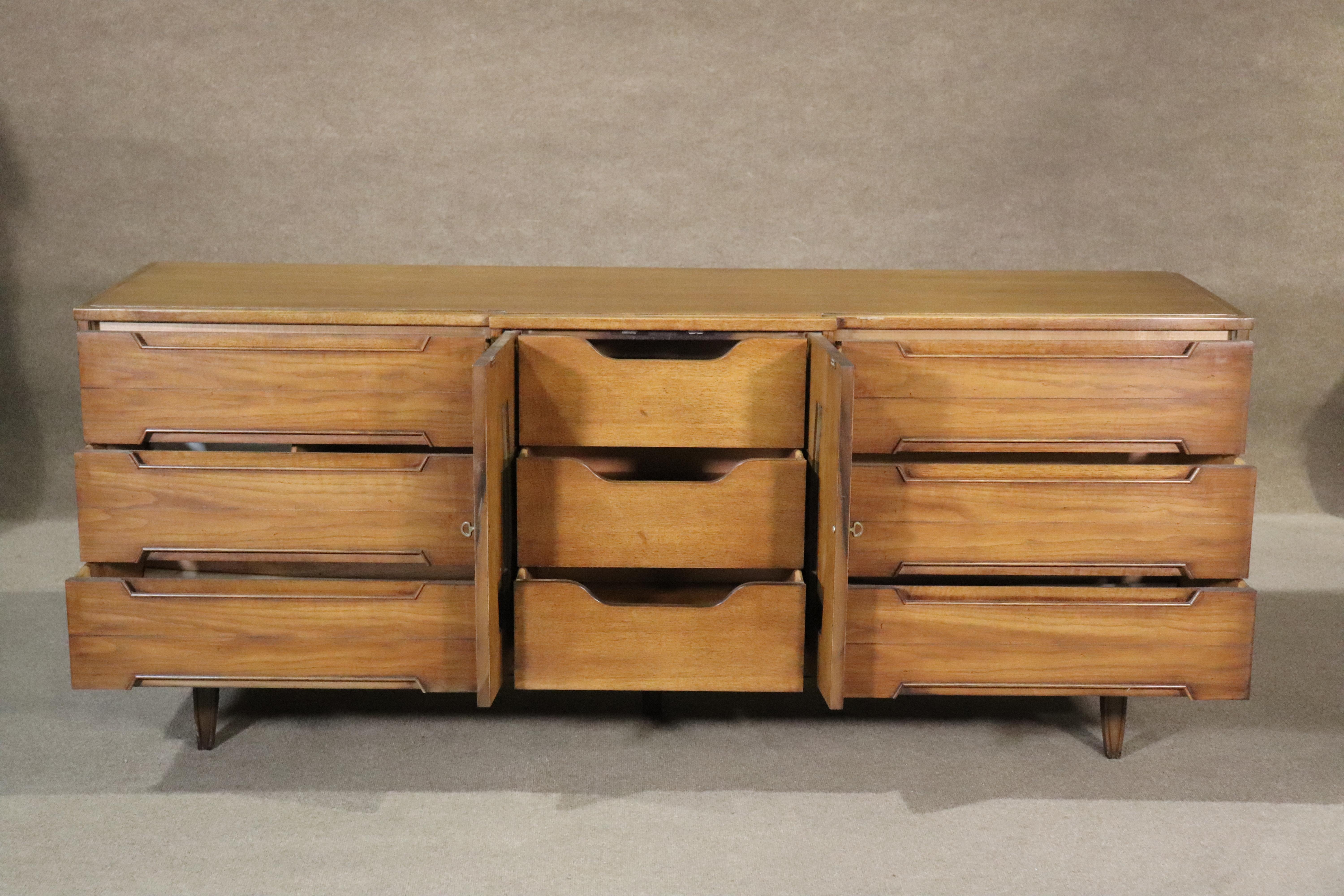 Long mid-century modern American dresser by Thomasville. Simple and handsome design with walnut wood grain. Nine total drawers with wood trim around the handles.
Please confirm location NY or NJ
