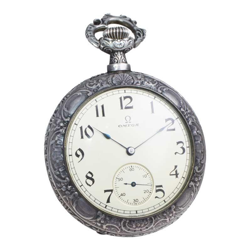 FACTORY / HOUSE: Omega Watch Company
STYLE / REFERENCE: Art Nouveau Style
METAL / MATERIAL: Sterling Silver
DIMENSIONS: Diameter 48mm 
CIRCA: 1900
MOVEMENT / CALIBER:  Manual Winding / 15 Jewels
DIAL / HANDS:  Silvered with Arabic Numbers / Blued