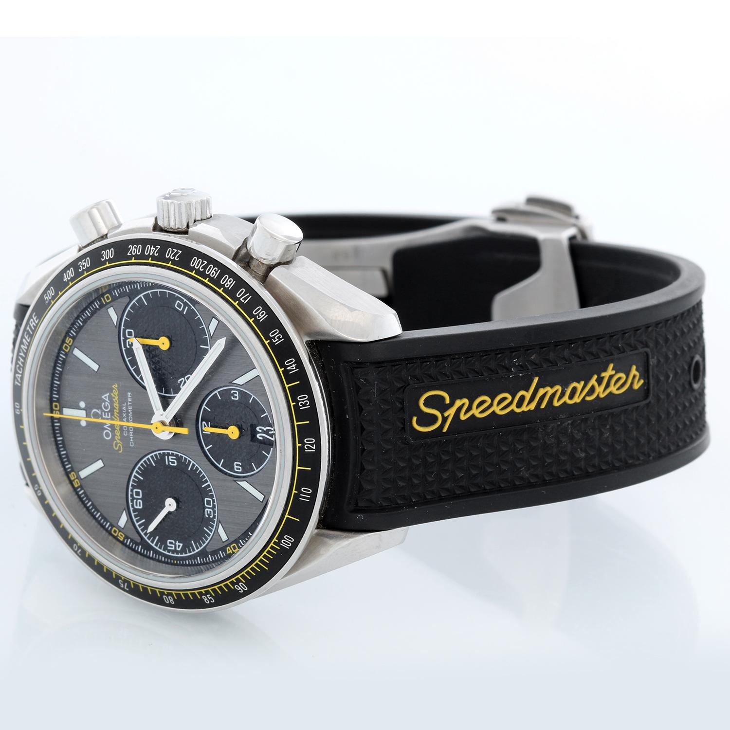 Omega Speedmaster Racing Co-Axial Chronometer Chronograph 40mm auf Kautschukband - Automatischer Aufzug. Gehäuse aus rostfreiem Stahl (40 mm Durchmesser). Graues Zifferblatt mit weißen und gelben Zeigern und Indexen. Omega Kautschukband mit