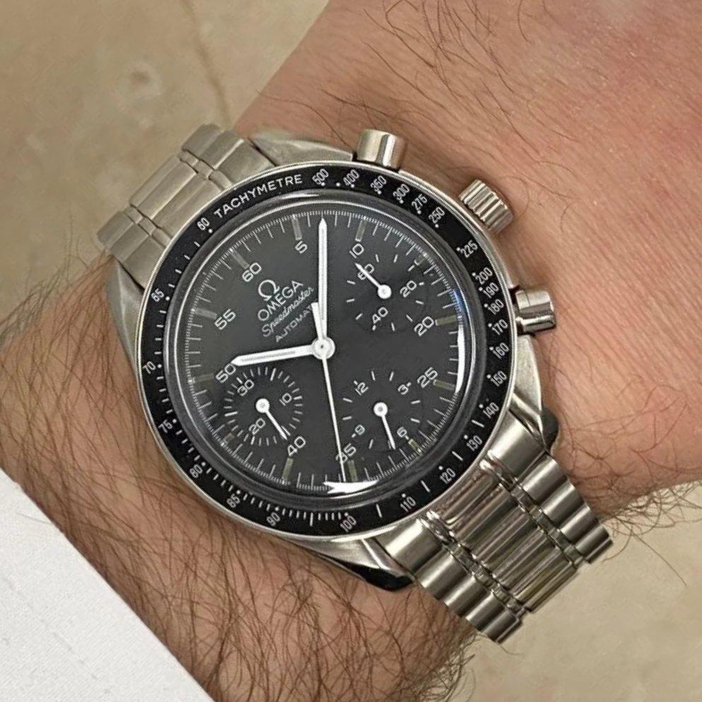 A vintage Omega Speedmaster Reduced chronograph wristwatch, crafted in stainless steel and featuring a striking black dial, circa 1990. This timepiece is a classic representation of Omega's enduring legacy in precision watchmaking. The Reduced