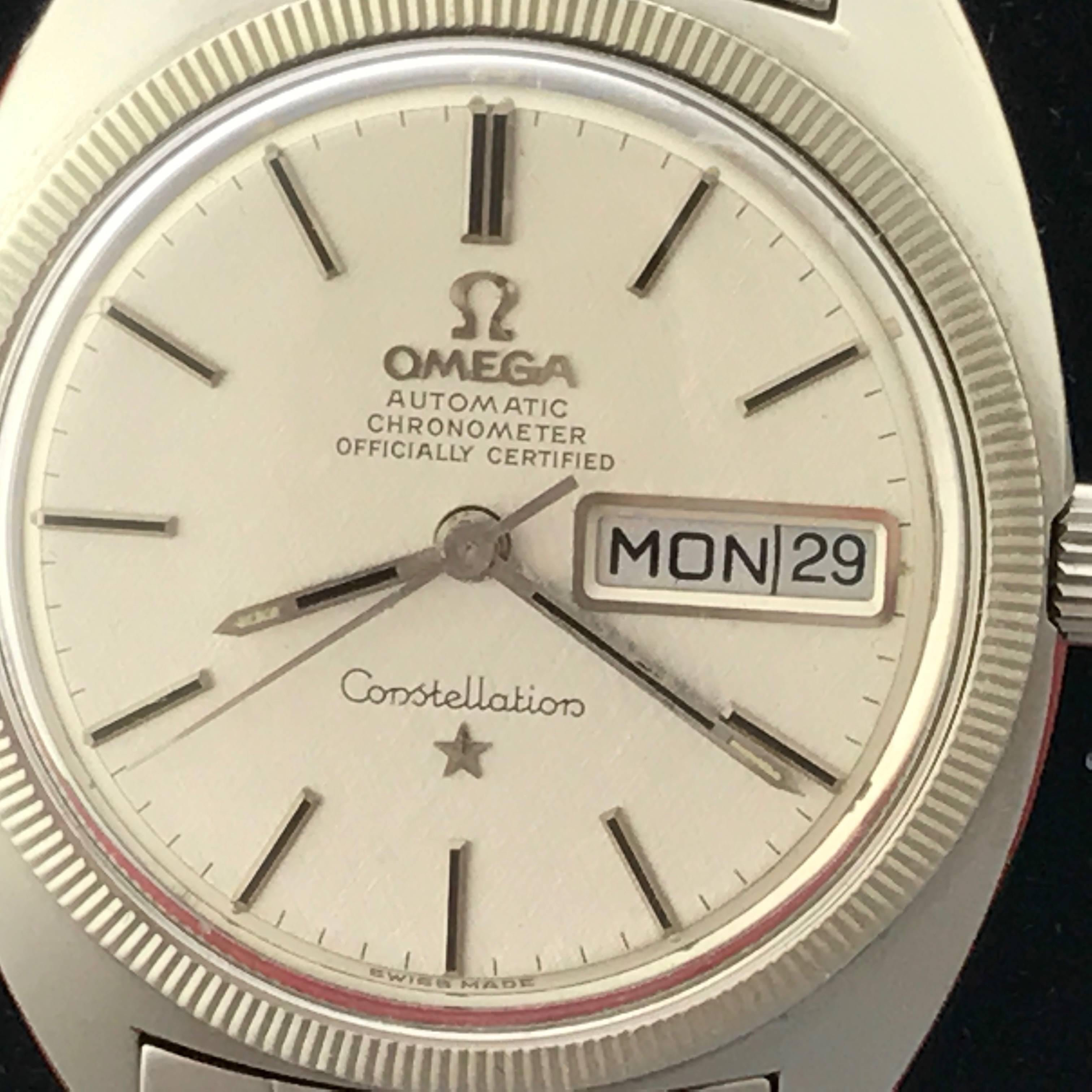 Omega Mens Constellation Vintage wristwatch. Automatic Winding with Day and Date. Silvered dial with polished hour markers. Stainless steel case with Observatory logo on back (35x 40mm). Stainless Steel Omega bracelet with fold-over Omega adjustable