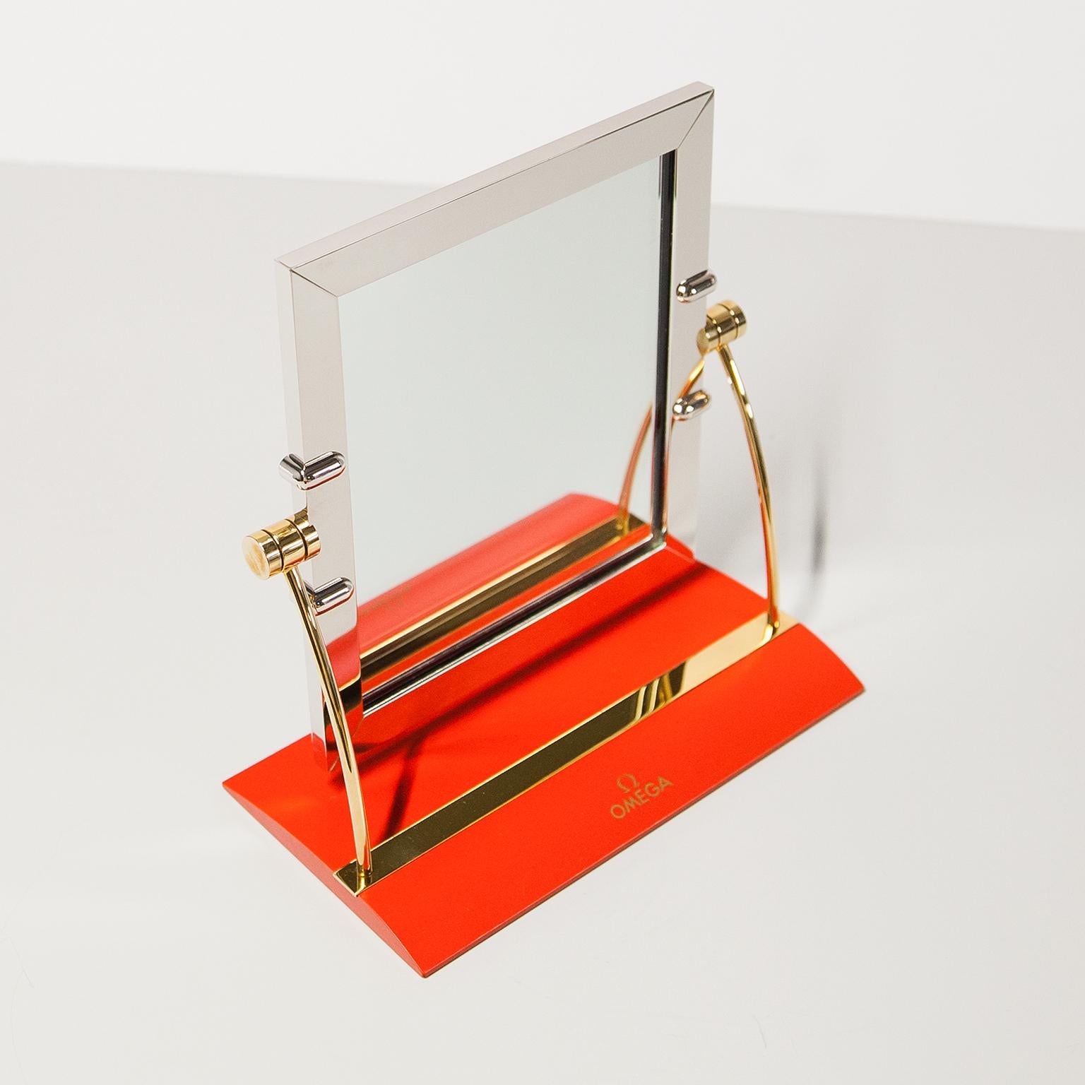 Original Omega verstellbarer Tisch-Ladenspiegel aus Stahl und rotem Leder. Ein Sammlerstück mit hohem Wiedererkennungswert und ein Muss für jeden Uhrenliebhaber oder Uhrenenthusiasten. In sehr gutem Vintage-Zustand, ohne Risse oder Brüche.