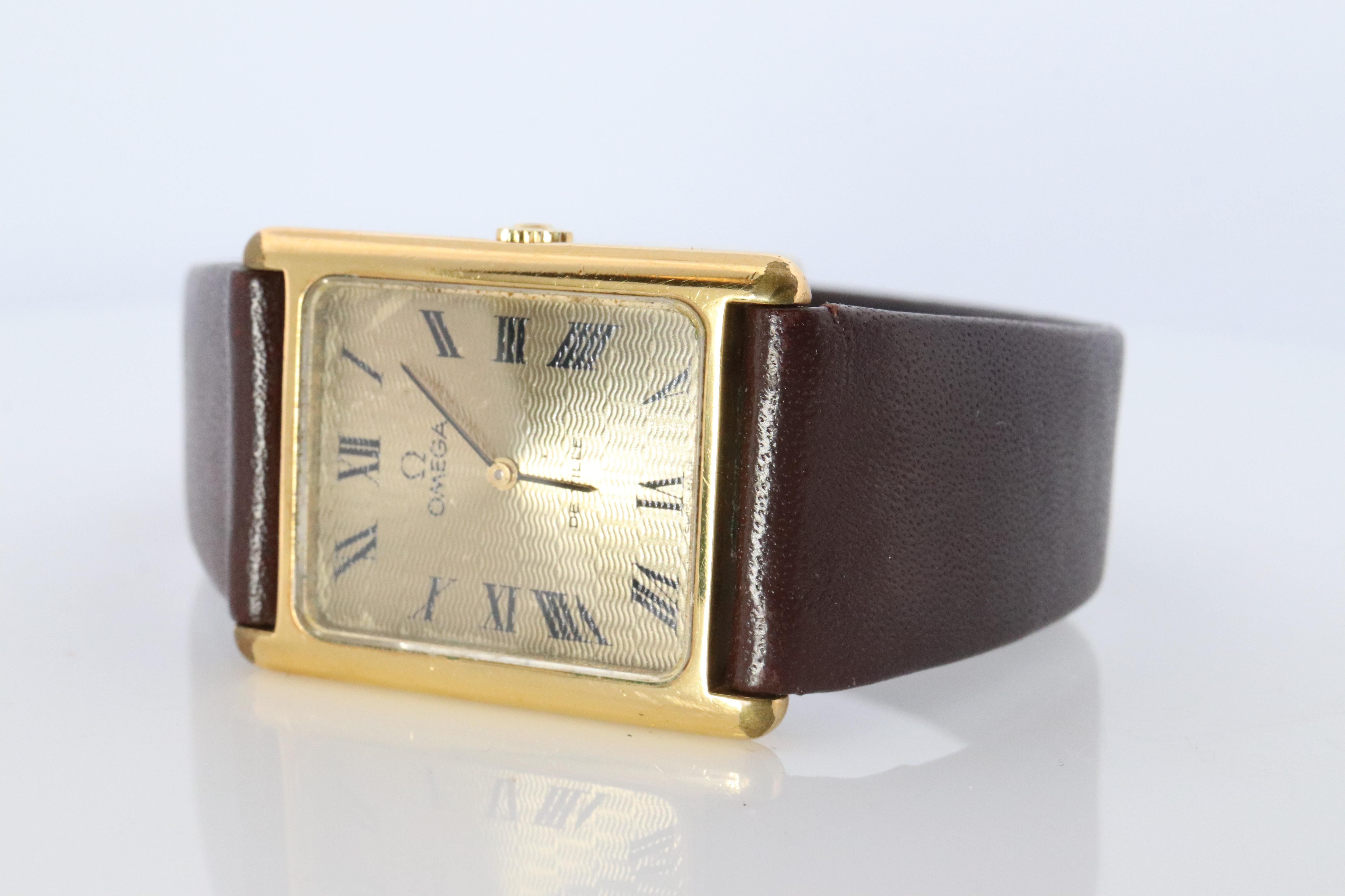 Stunning watch piece. 
OMEGA TANK DeVille
Windup mechanical movement.



DeVille


Stainless Steel Case Gold plated and Original Omega Band

Condition: Winds up and keeps time.


Details:
24mm by 32mm case