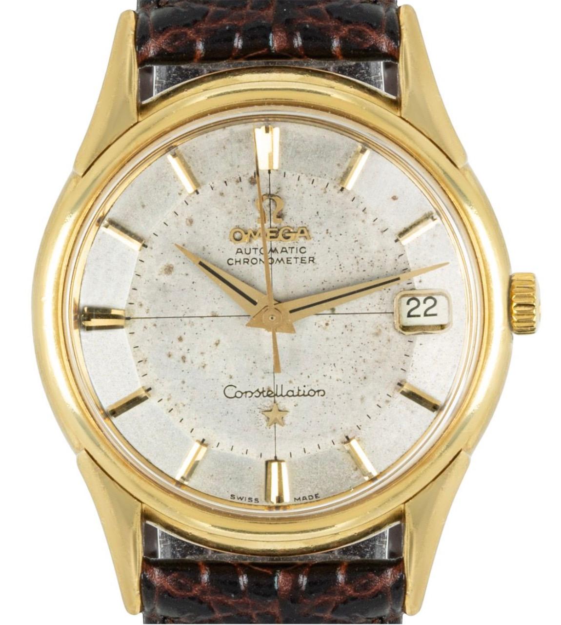 Eine Vintage Omega Consteallion Armbanduhr in Gelbgold. Sie verfügt über ein markantes Tortenform-Zifferblatt mit aufgesetzten Indexen, eine Datumsanzeige und eine Lünette aus Gelbgold. Die Uhr ist außerdem mit einem Kunststoffglas, einem