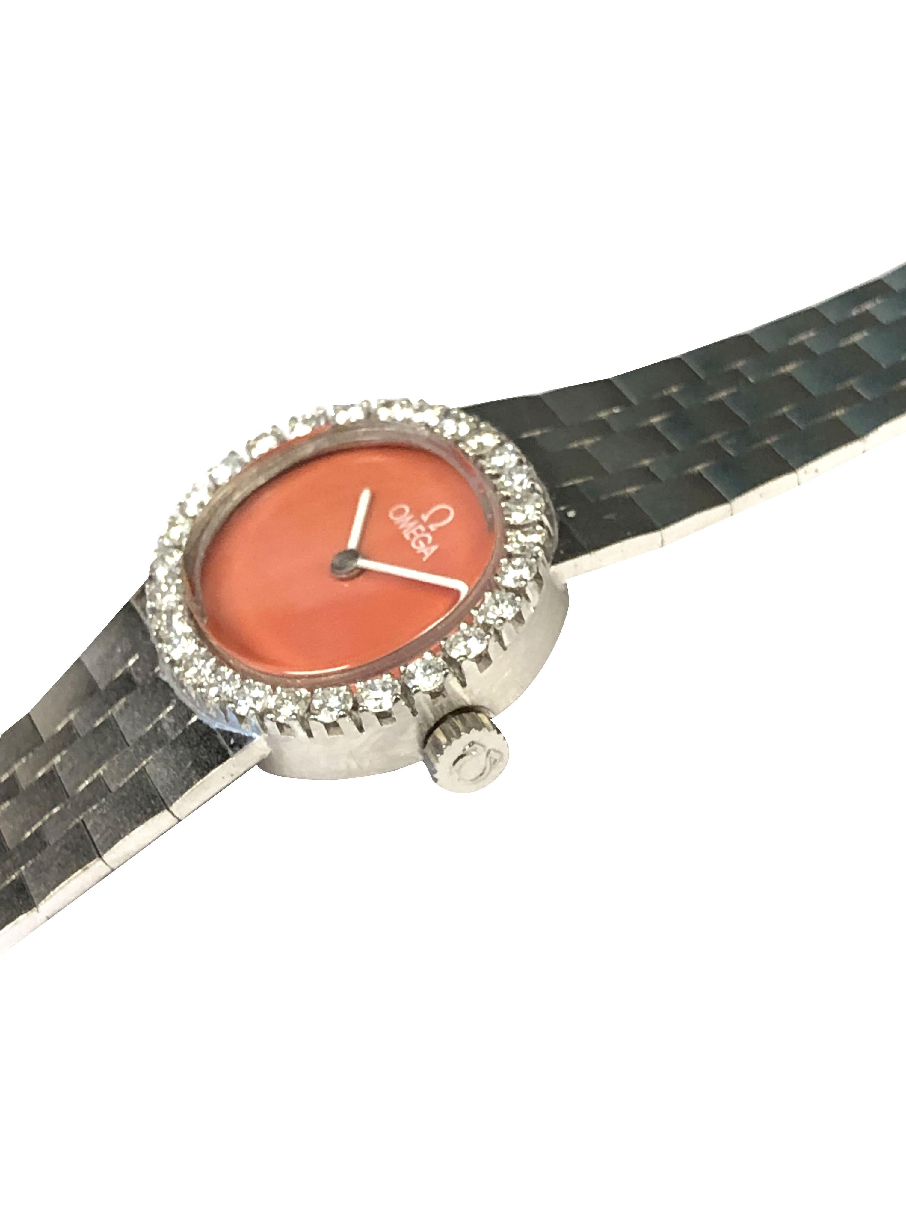 Circa 1980 Omega Ladies Wrist Watch, 23 X 20 M.M. 18K White Gold 2 Piece case, Round Brilliant cut Diamond bezel totaling 1 Carat. 17 Jewel Mechanical, manual wind movement, Coral dial. 5/8 inch wide tapering 18K White Gold Brick link bracelet with