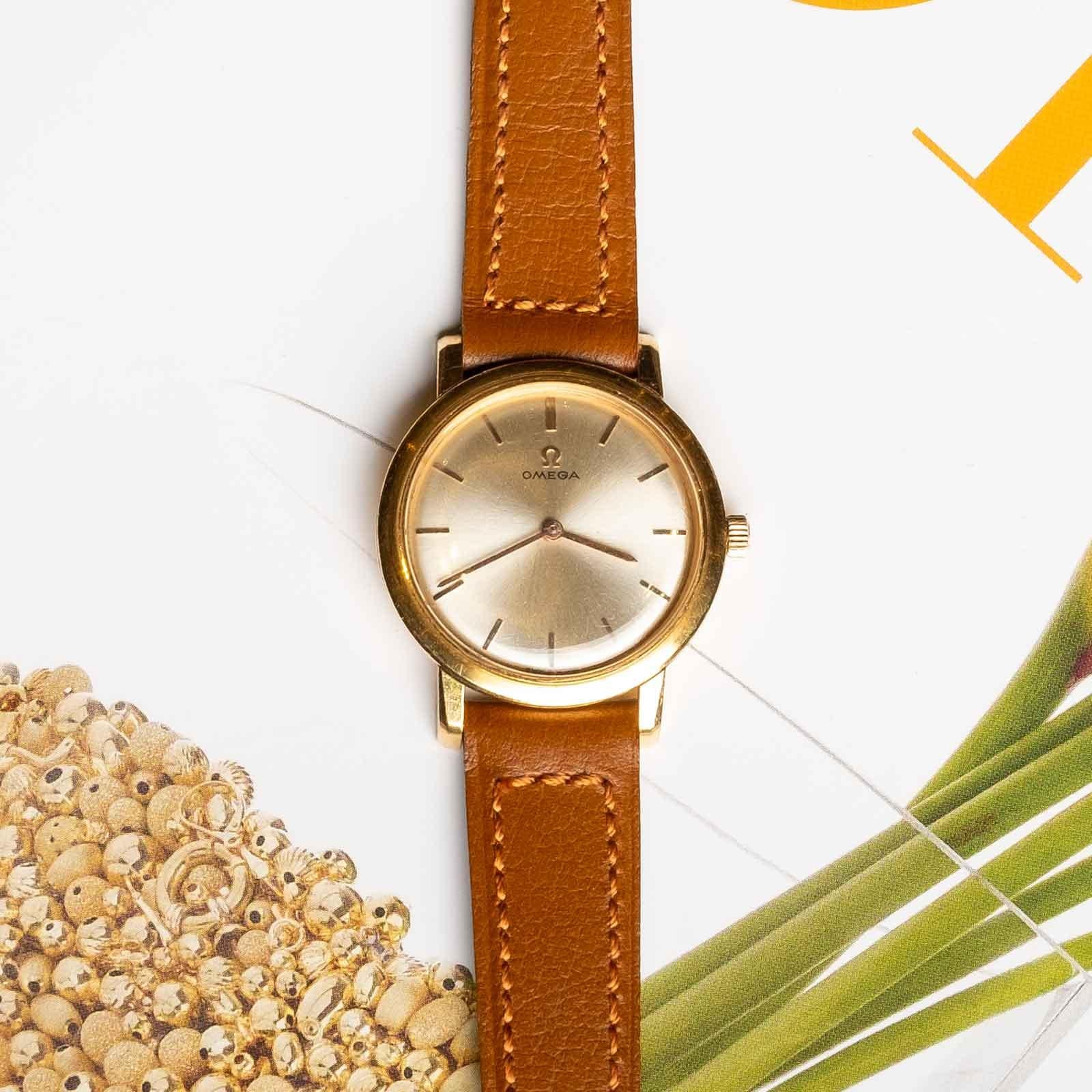 Elegante Omega-Damenuhr aus 18-karätigem Gold, etwa aus den 1960er/70er Jahren. Dieser Zeitmesser verfügt über ein für die damalige Zeit typisches Handaufzugswerk, das seinen Vintage-Charme und die feine Schweizer Handwerkskunst unterstreicht.

Eine